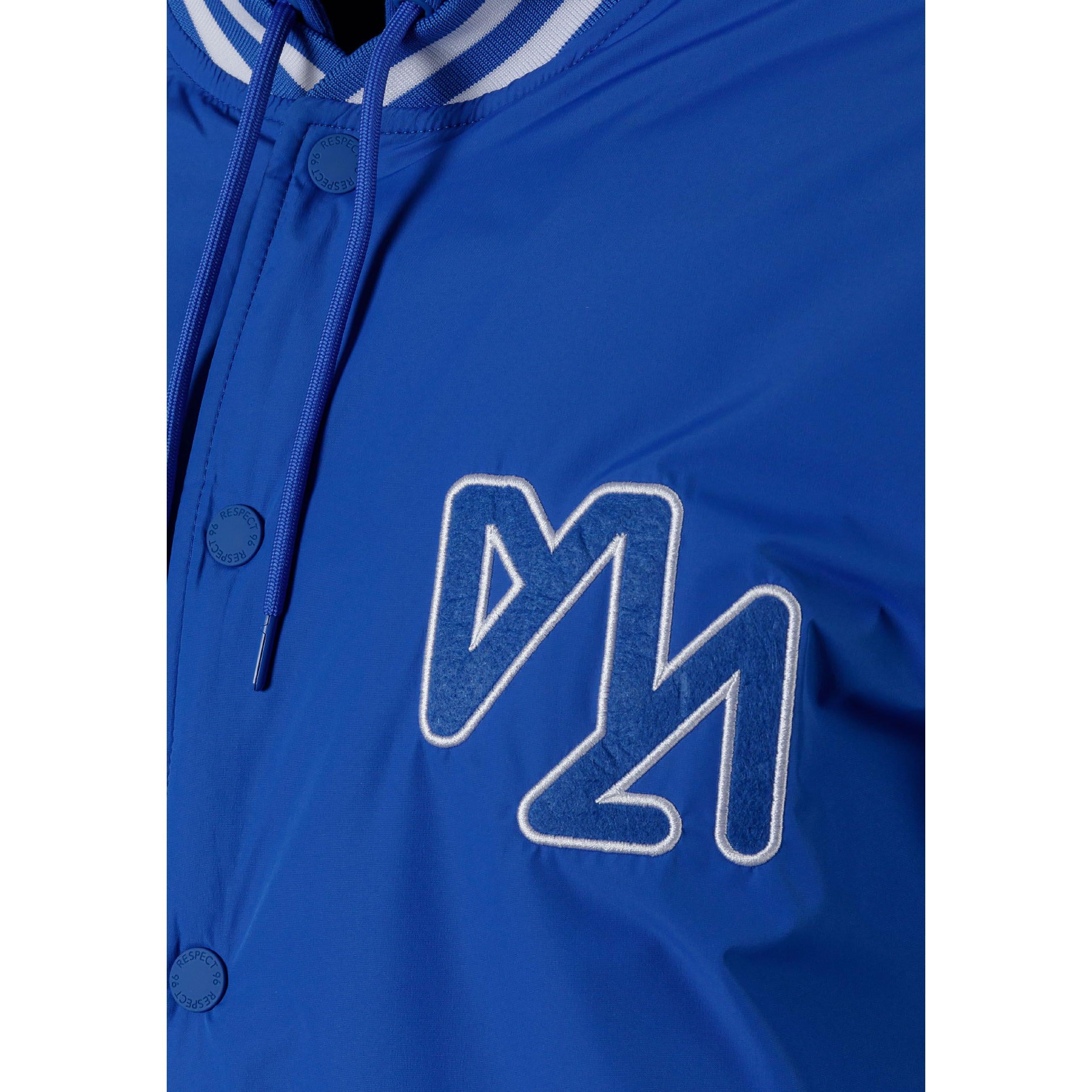 Close-up detail of cobalt blue jacket showing zip closure with matching blue zipper tape and snap button details