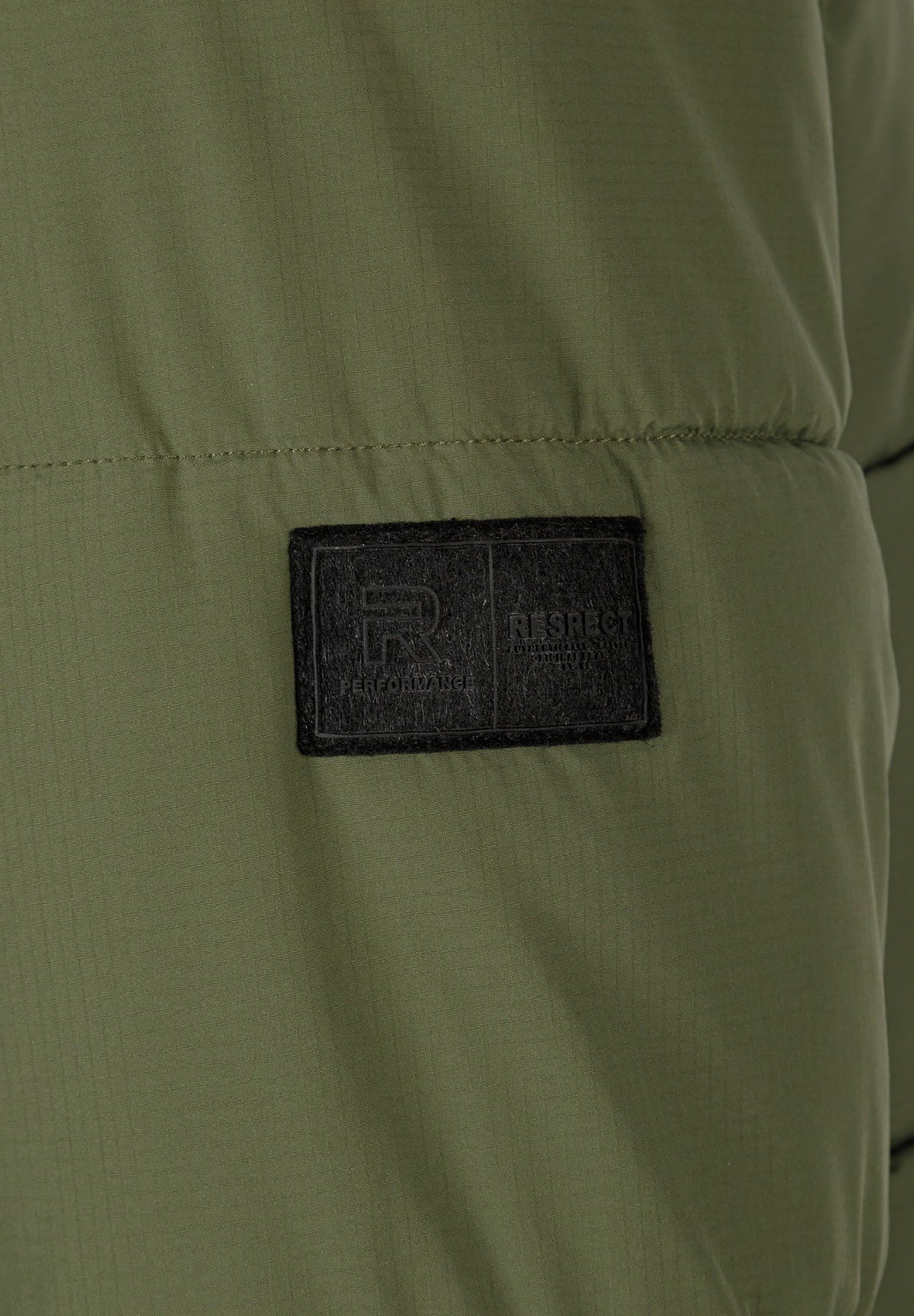 Close-up of the sleeve patch on the khaki puffer jacket.