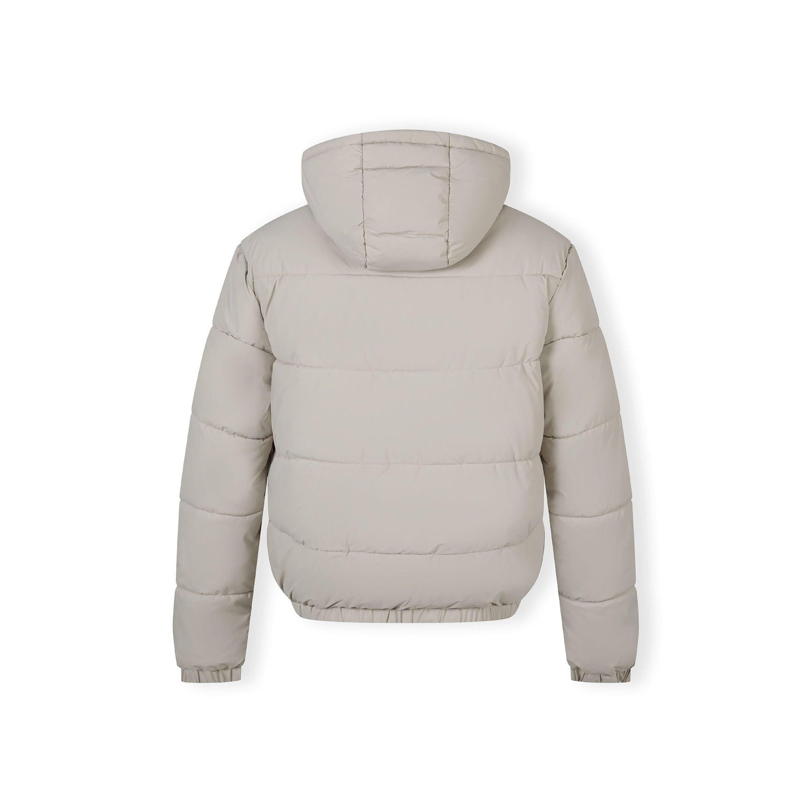 Close-up detail of black rectangular fabric label patch sewn on grey ripstop jacket sleeve showing textured fabric surface