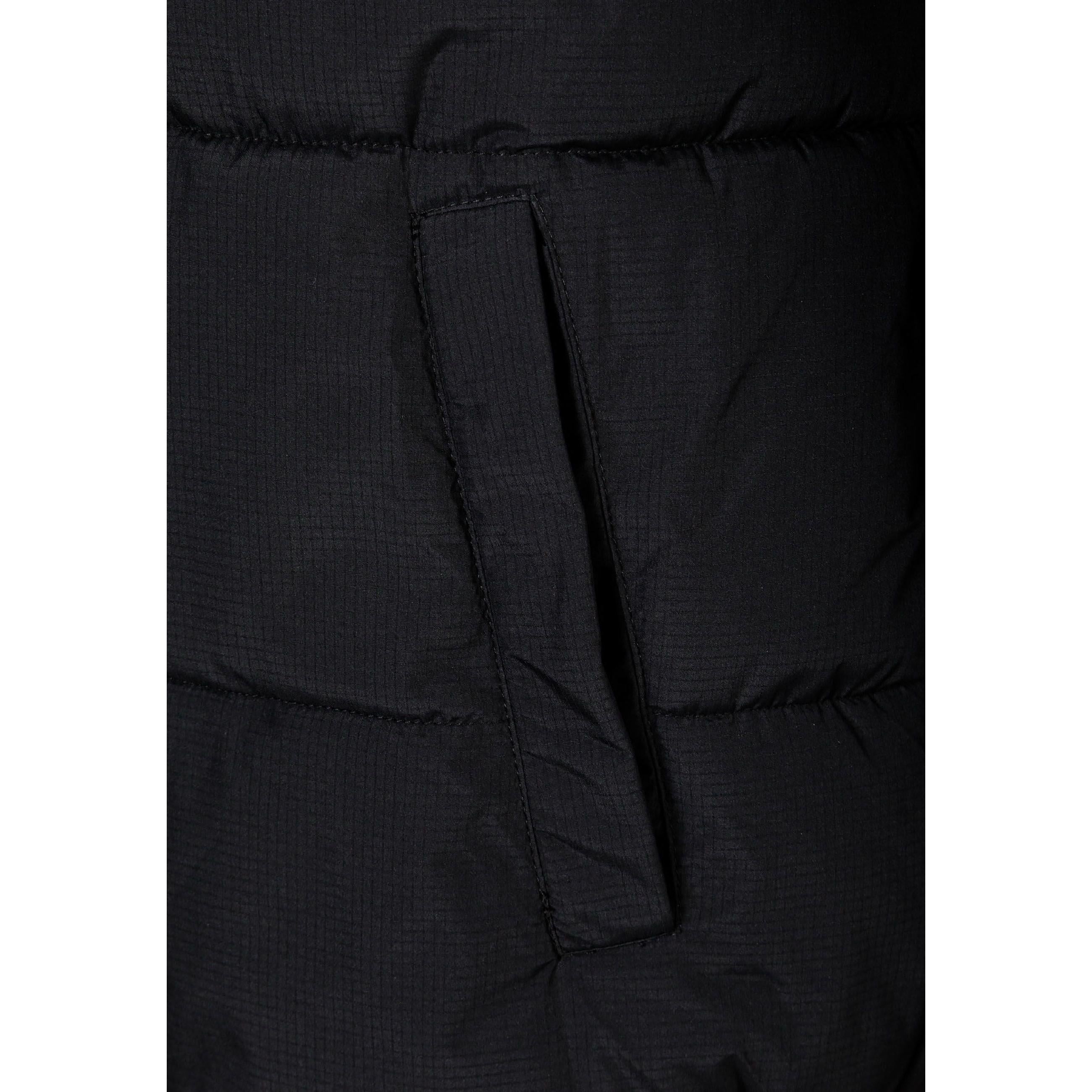 Close up detail of black fabric label patch on sleeve showing textured ripstop material