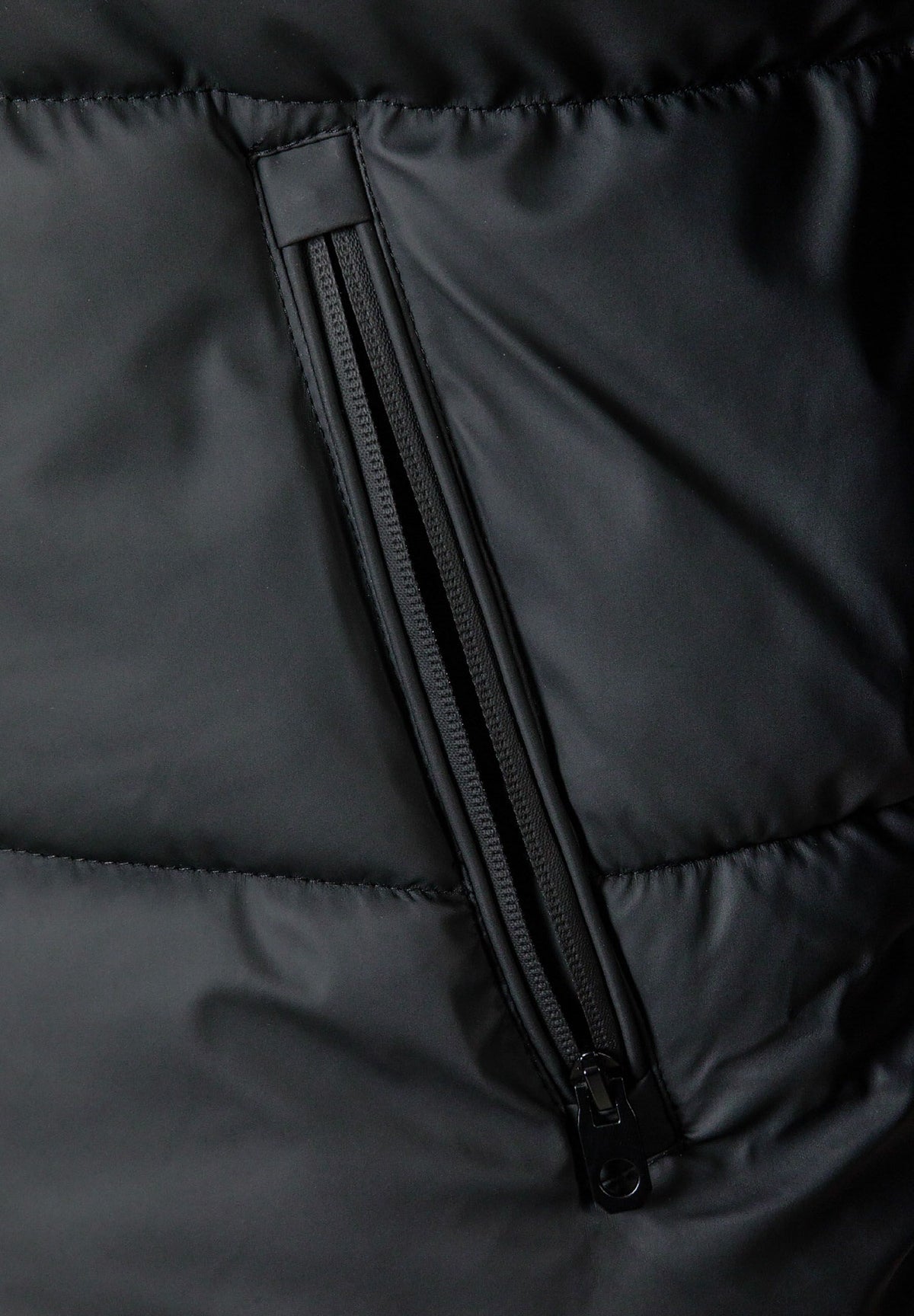 Close-up of the pocket on the black puffer jacket.