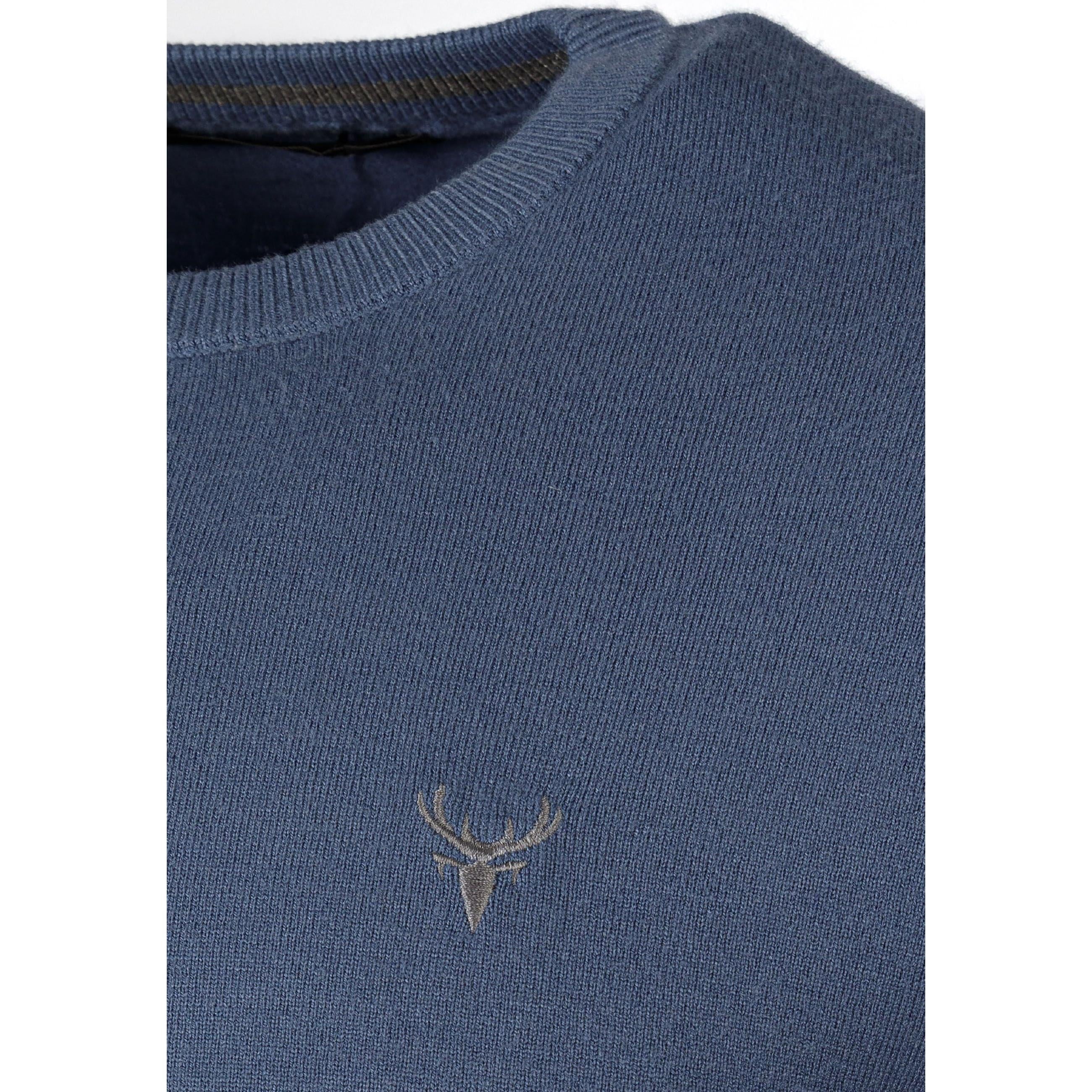 Close-up detail of blue fine knit jumper showing crew neckline and small embroidered logo on chest