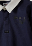 Close-up of a navy boys long sleeve polo shirt with a structured collar and chest graphic.