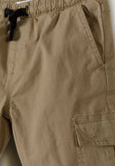 Detail of boys' grey woven cargo trousers with elastic waistband and side pockets.