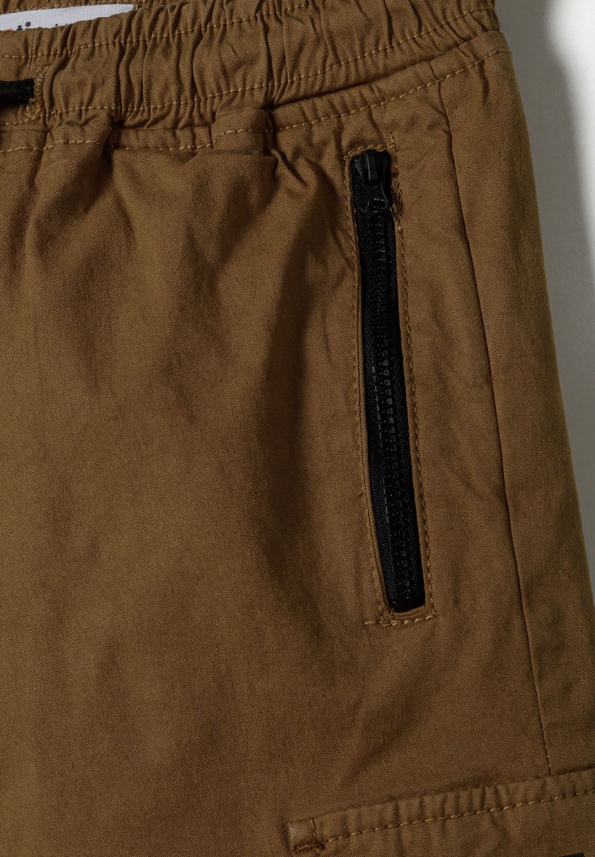 Brown cargo trousers, zipped side pocket and elasticated waist.