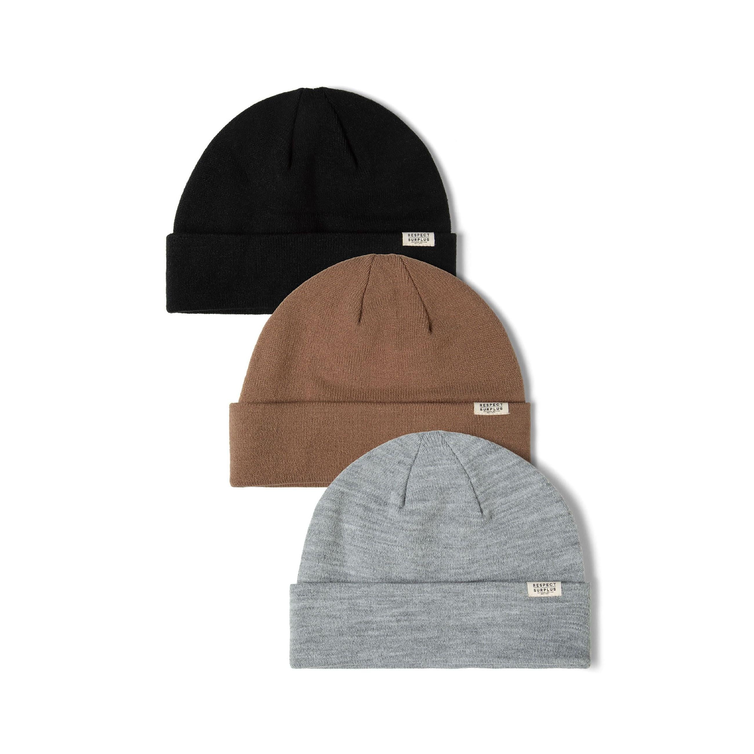 Three ribbed beanie hats in black, brown, and grey with fold-up cuffs and small badges.