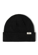 Close-up of a black ribbed beanie hat with a fold-up cuff and a small logo badge.