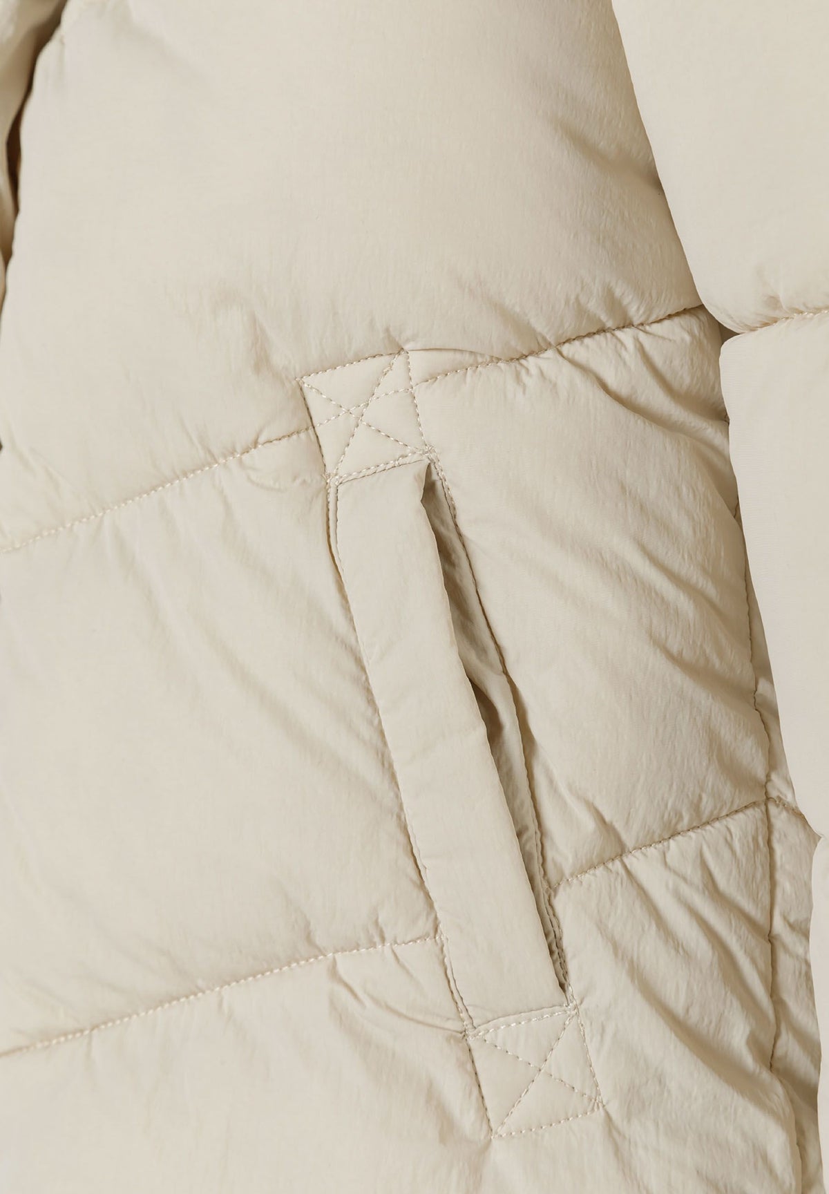 Close-up of the pocket on the cream long puffer coat.