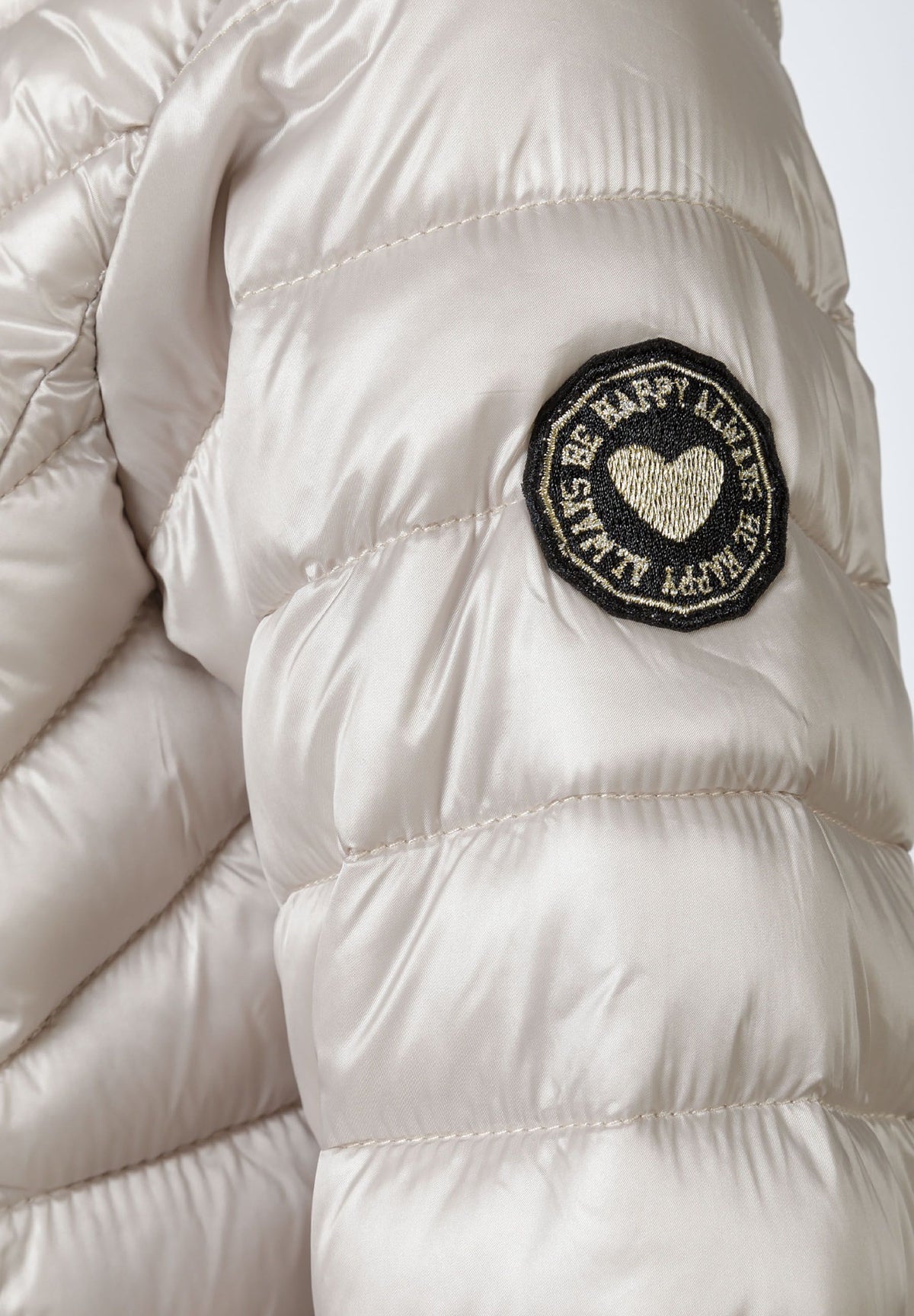 Close-up of the sleeve patch on the light grey puffer jacket.