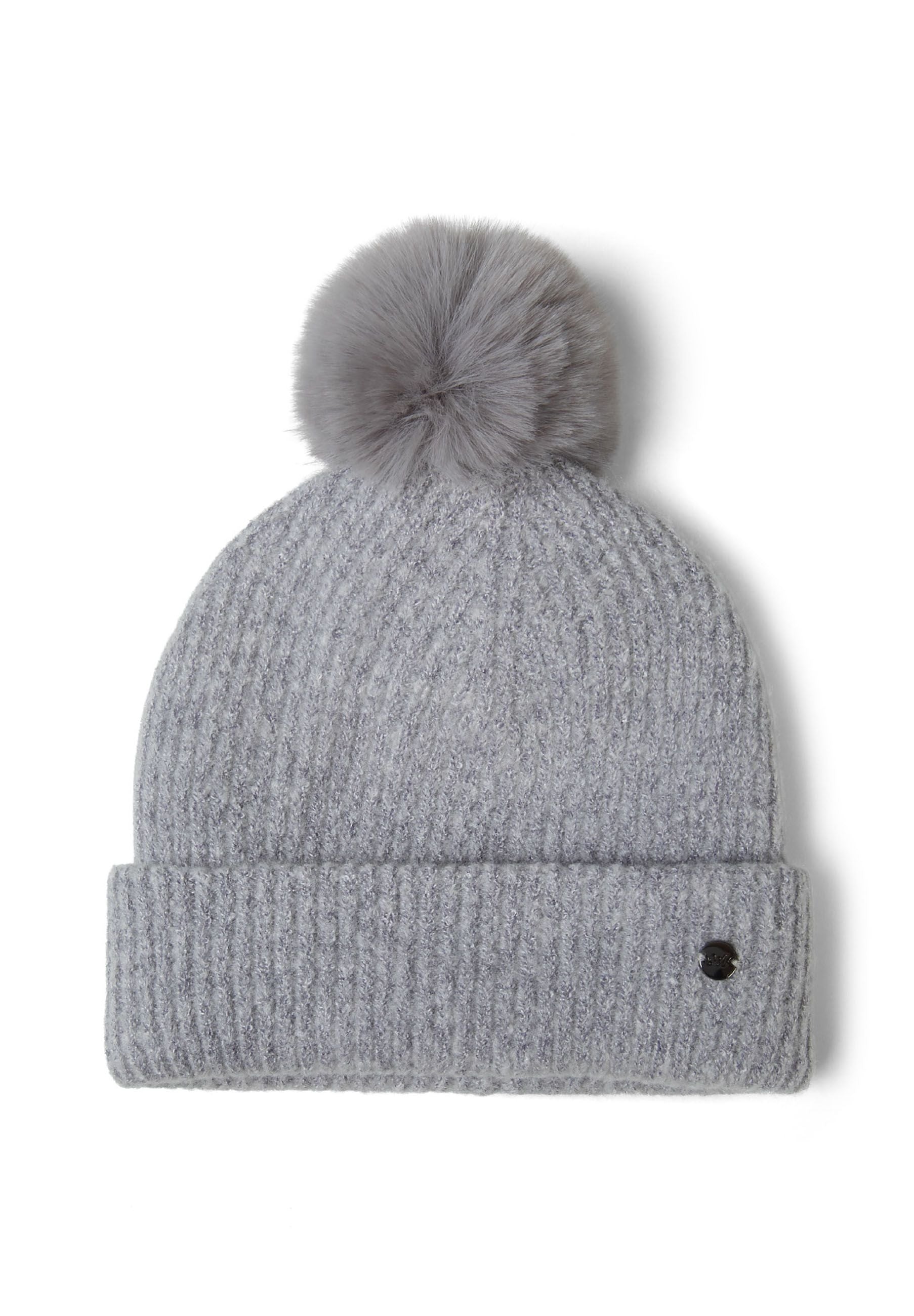 Detail of a grey ribbed knit hat with a pompom and metal badge.