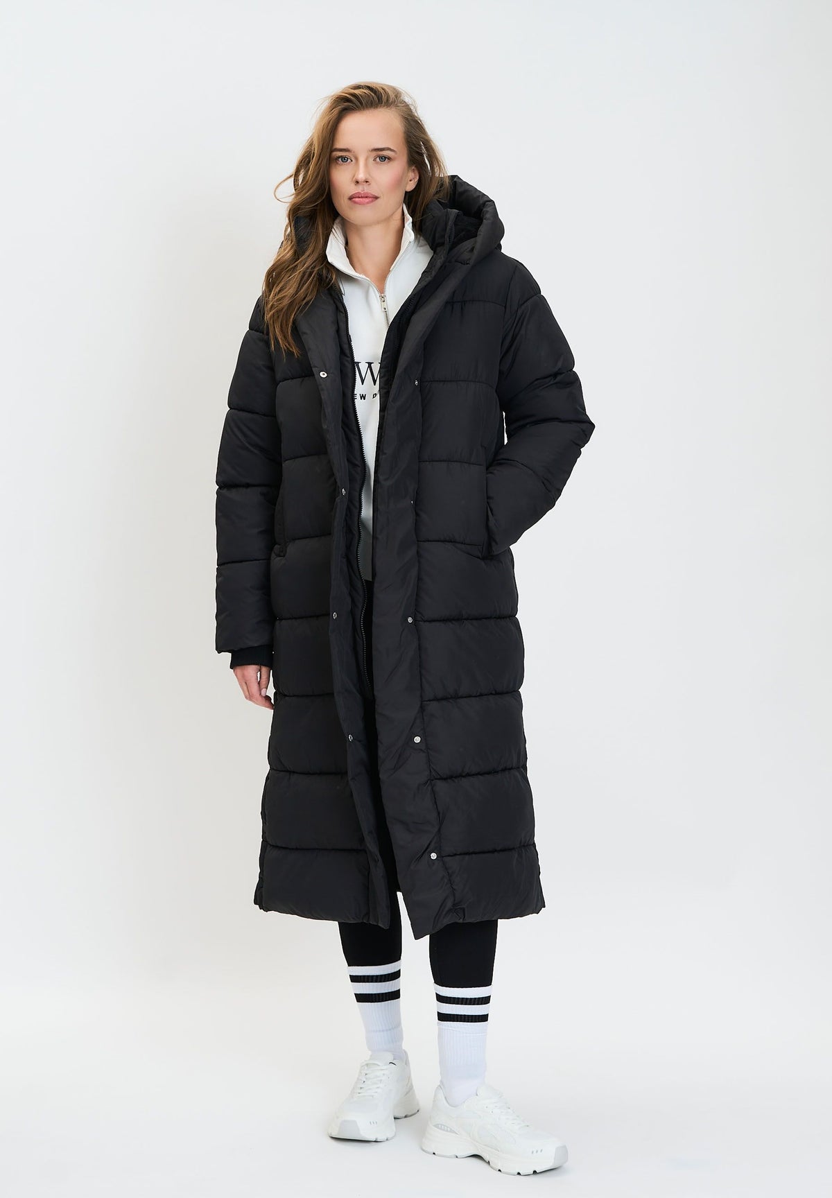 Women's black long puffer coat, shown worn.