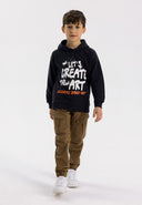 Boys brown knitted cargo trousers with drawcord, front view, featuring multiple pockets and ribbed cuffs.