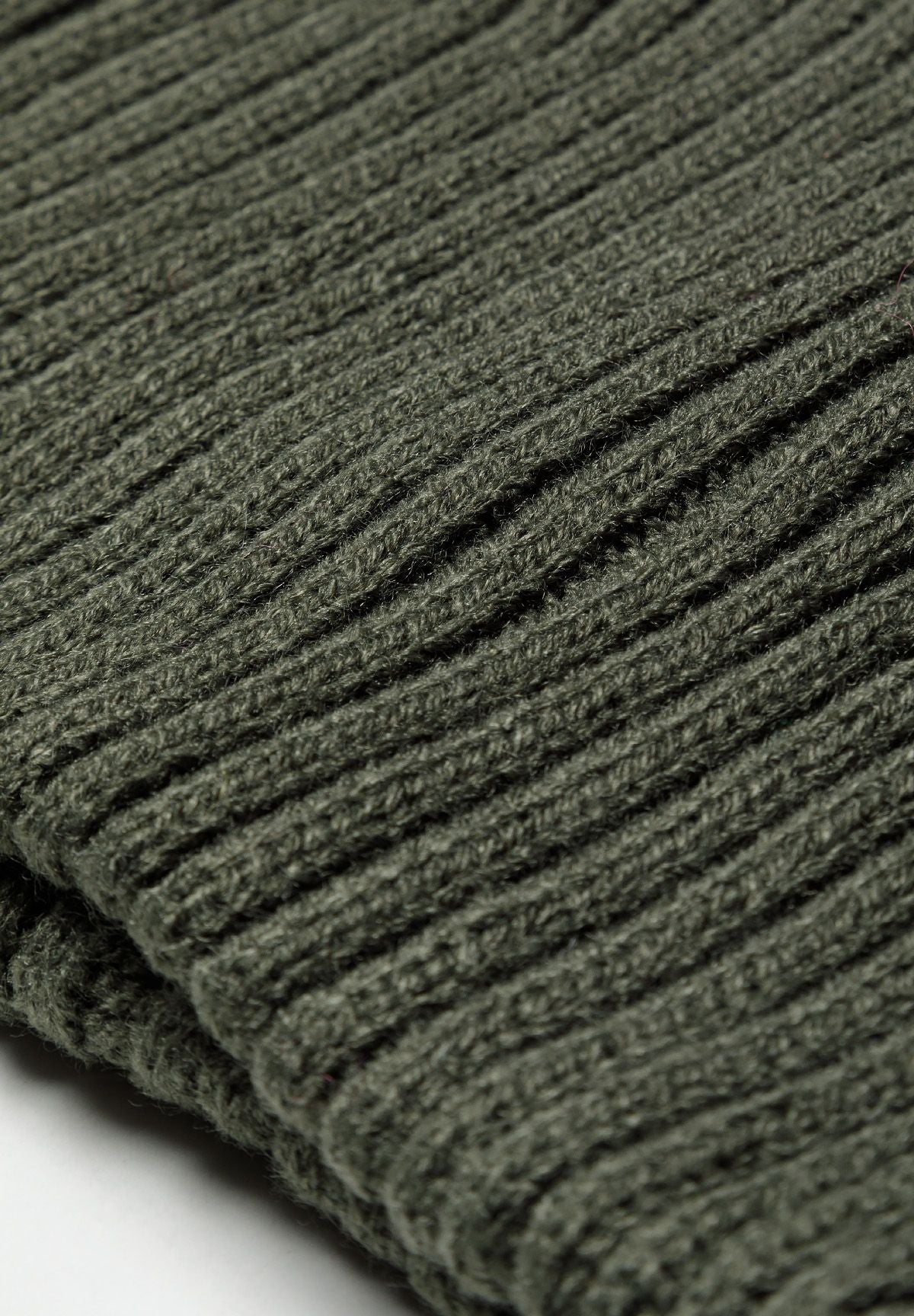 Extreme close-up of olive snood edge showing dense raised rib stitches.