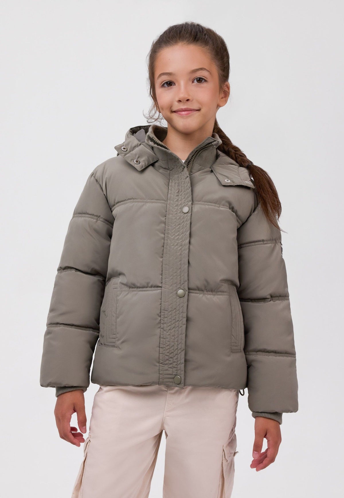 Girl wearing a khaki padded hooded jacket with snap-front placket, high collar and two welt pockets.