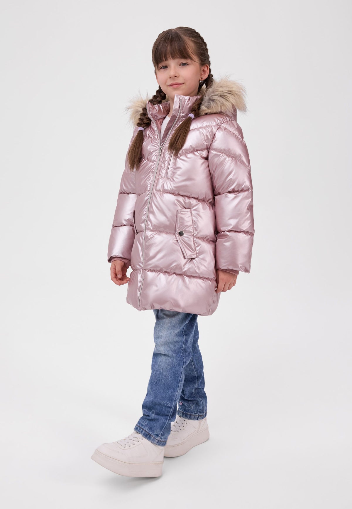 Girl wearing a metallic pale pink padded coat with fluffy hood trim, diagonal quilting and flap pockets.