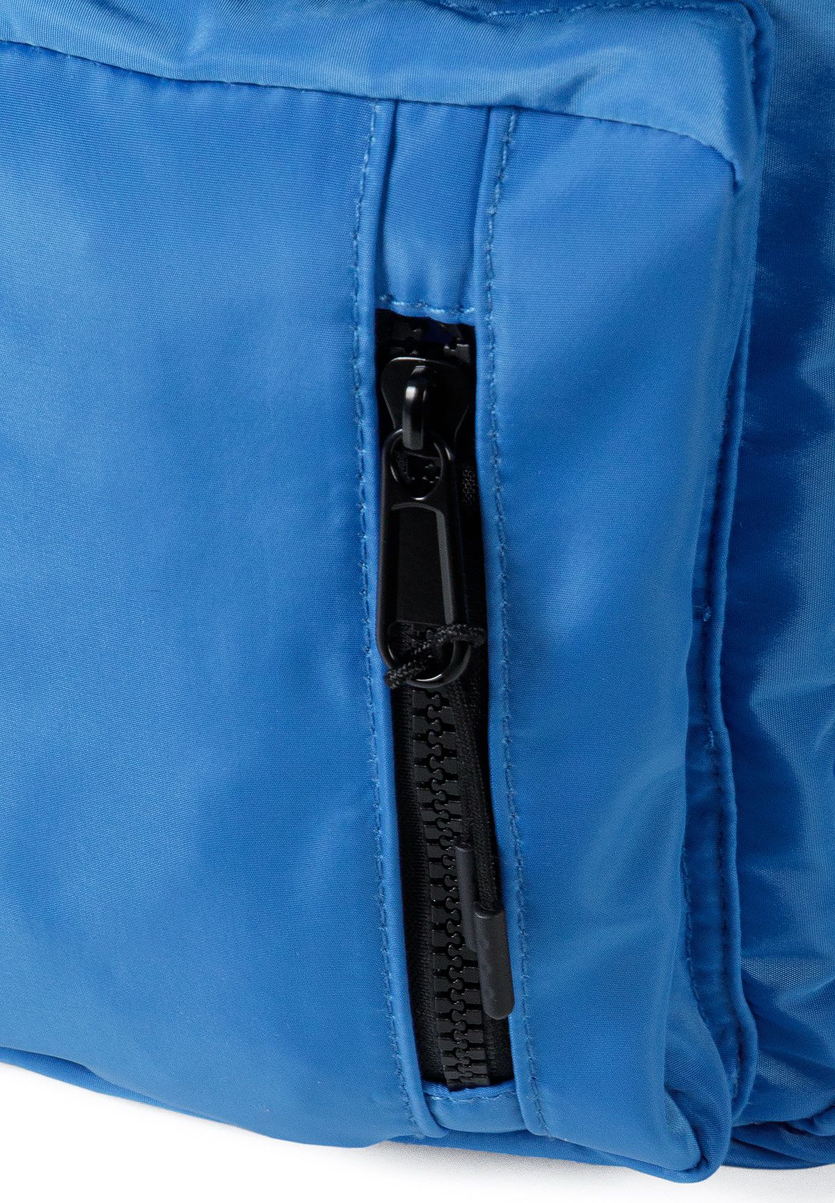Blauwe rugzak voor meisjes met glanzende badges, detail van het vak met ritssluiting.