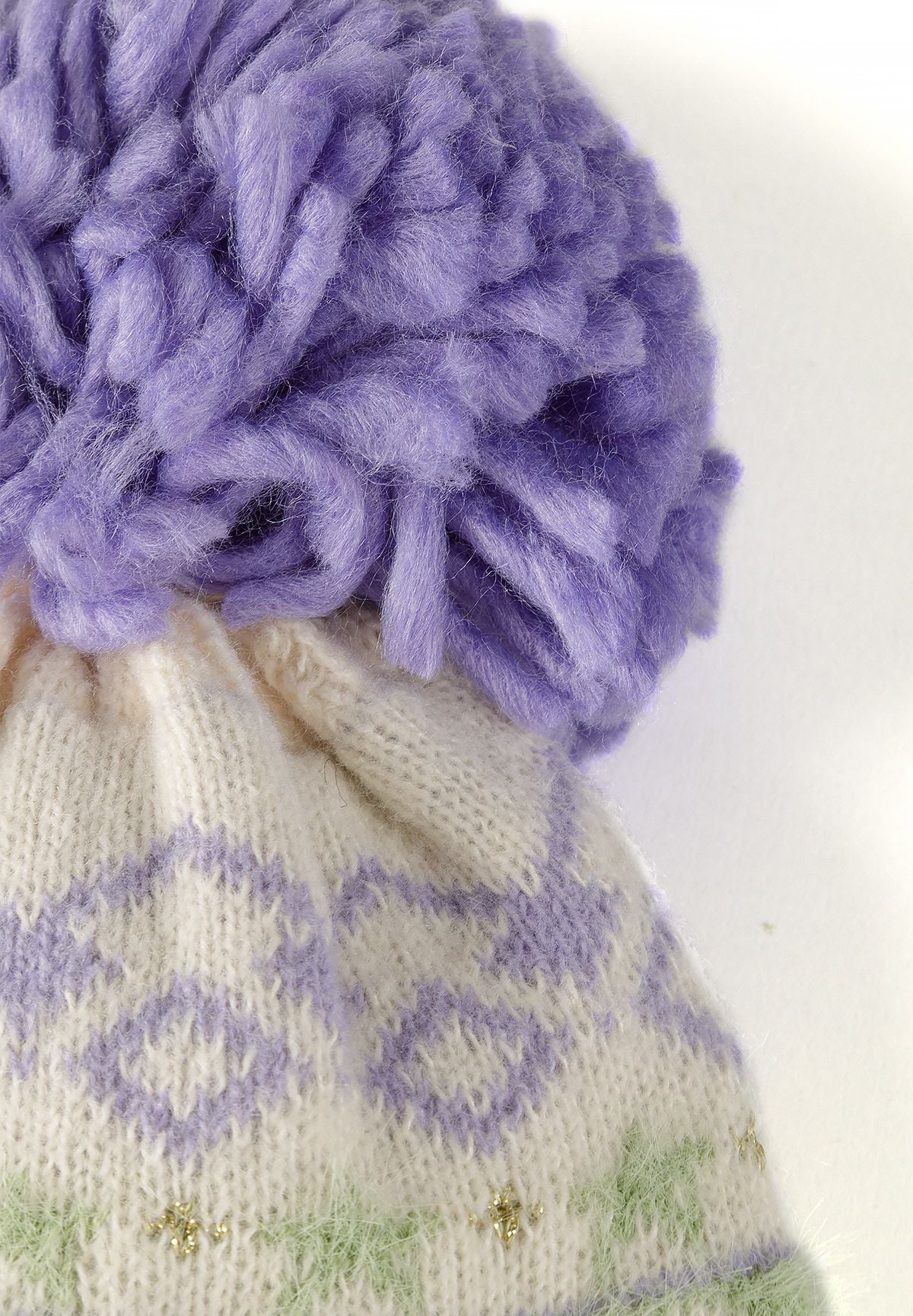 Set met een crèmekleurige muts met patroon, sjaal en handschoenen voor meisjes, detail van de pompon.