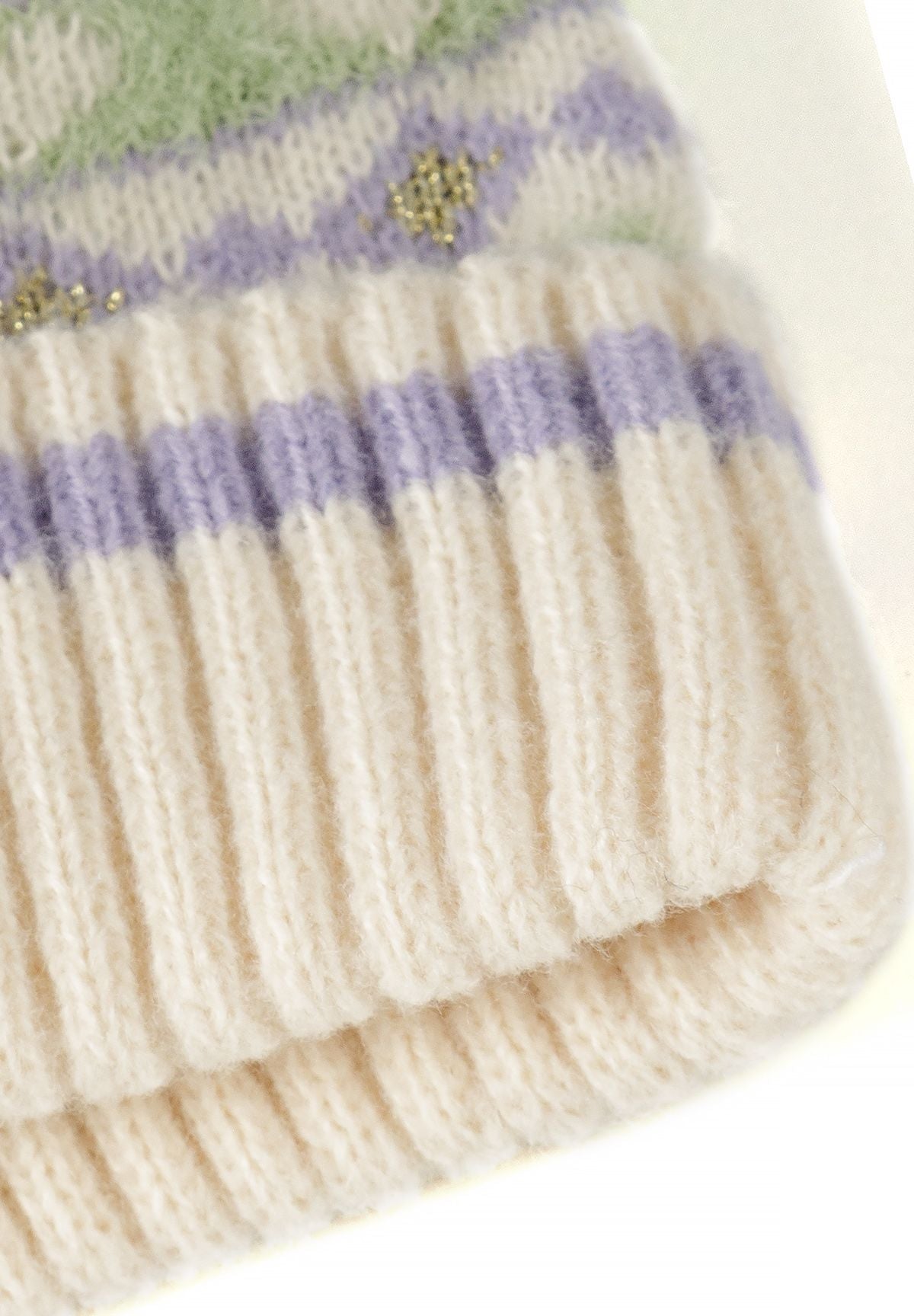 Set met een crèmekleurige muts met patroon, sjaal en handschoenen voor meisjes, detail van het breipatroon van de muts.