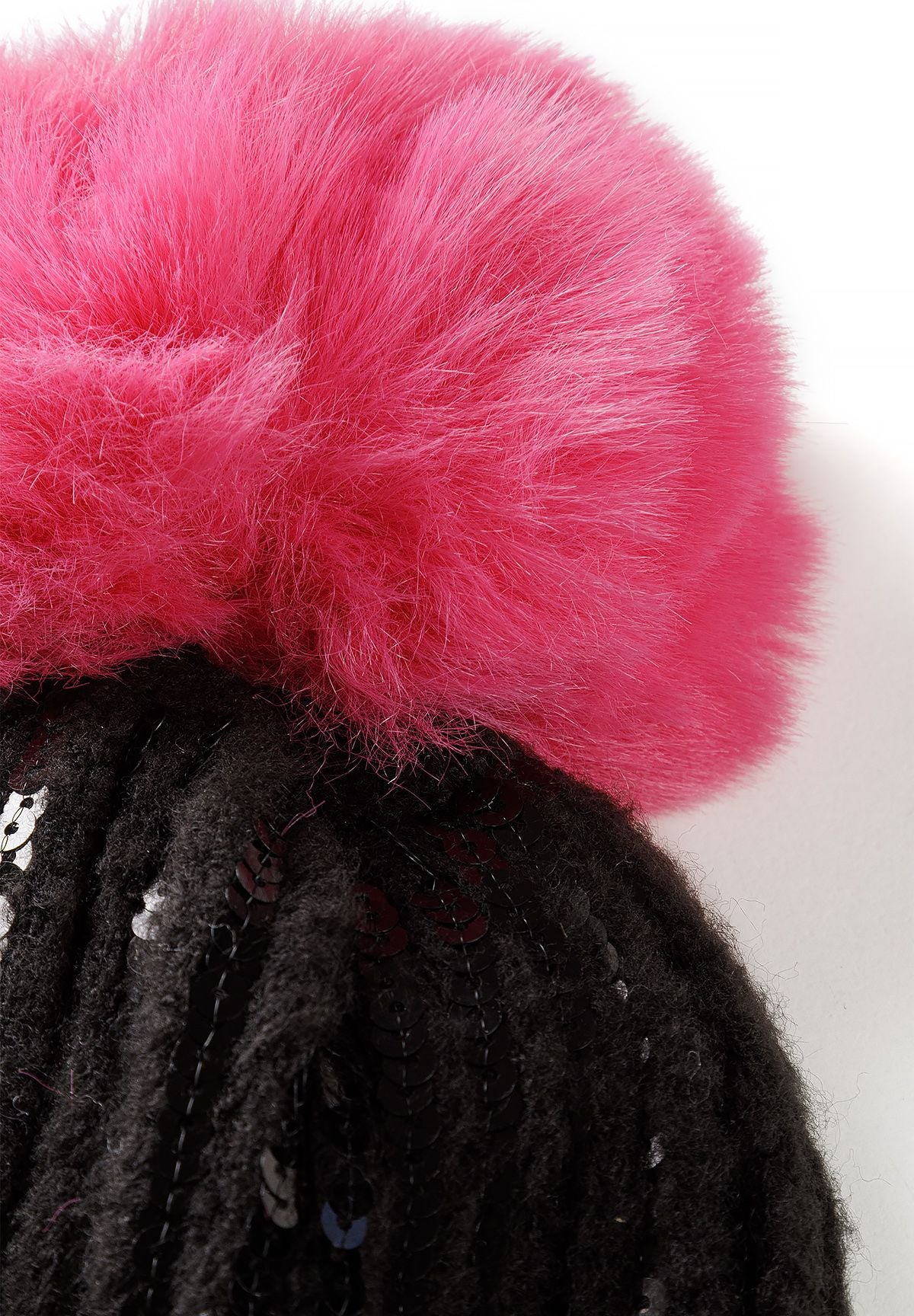 Bonnet en maille à paillettes noir pour fille avec pompon en fausse fourrure rose, gros plan sur le pompon en fausse fourrure.