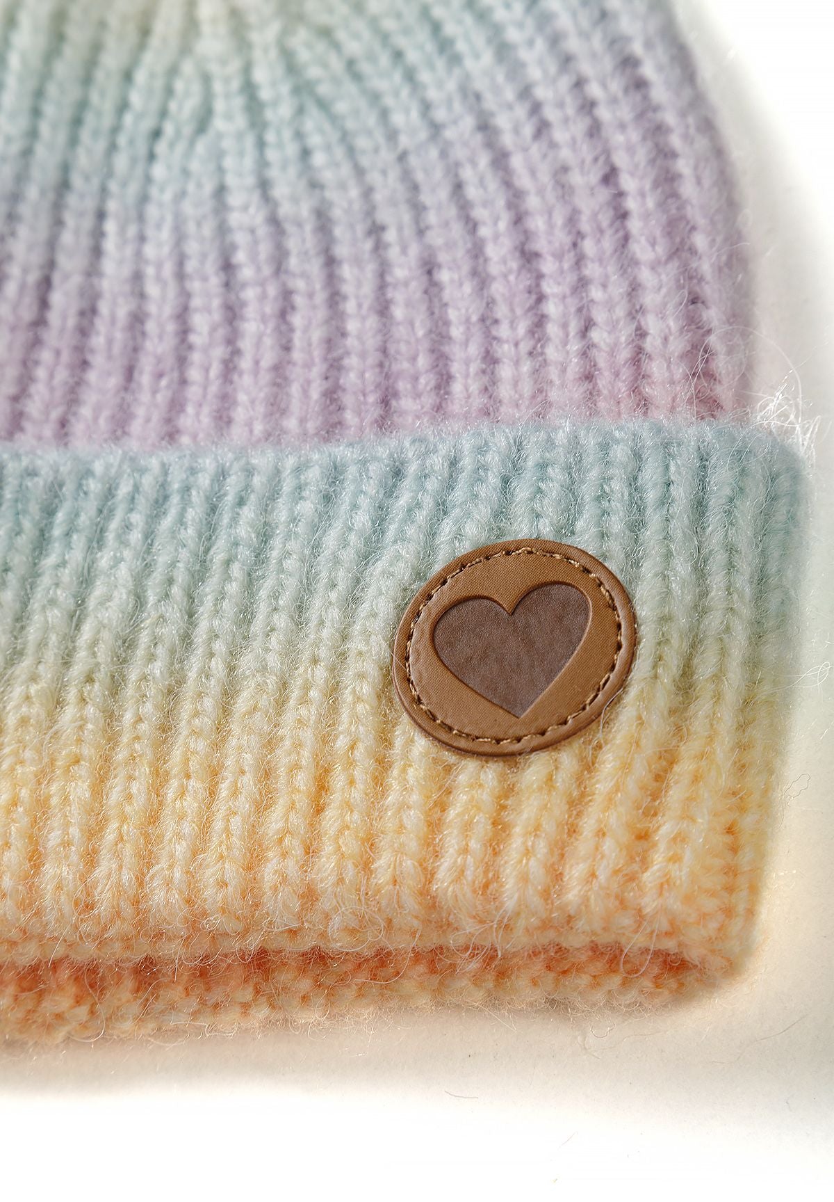Ensemble bonnet et écharpe arc-en-ciel lilas pour fille, gros plan sur l'écusson en forme de cœur.