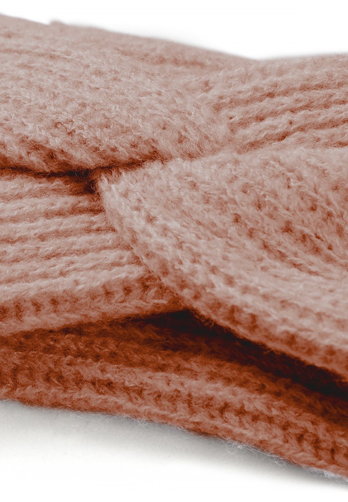 Close-up of the dusty pink headband's overlapping front twist and soft knit stitches.