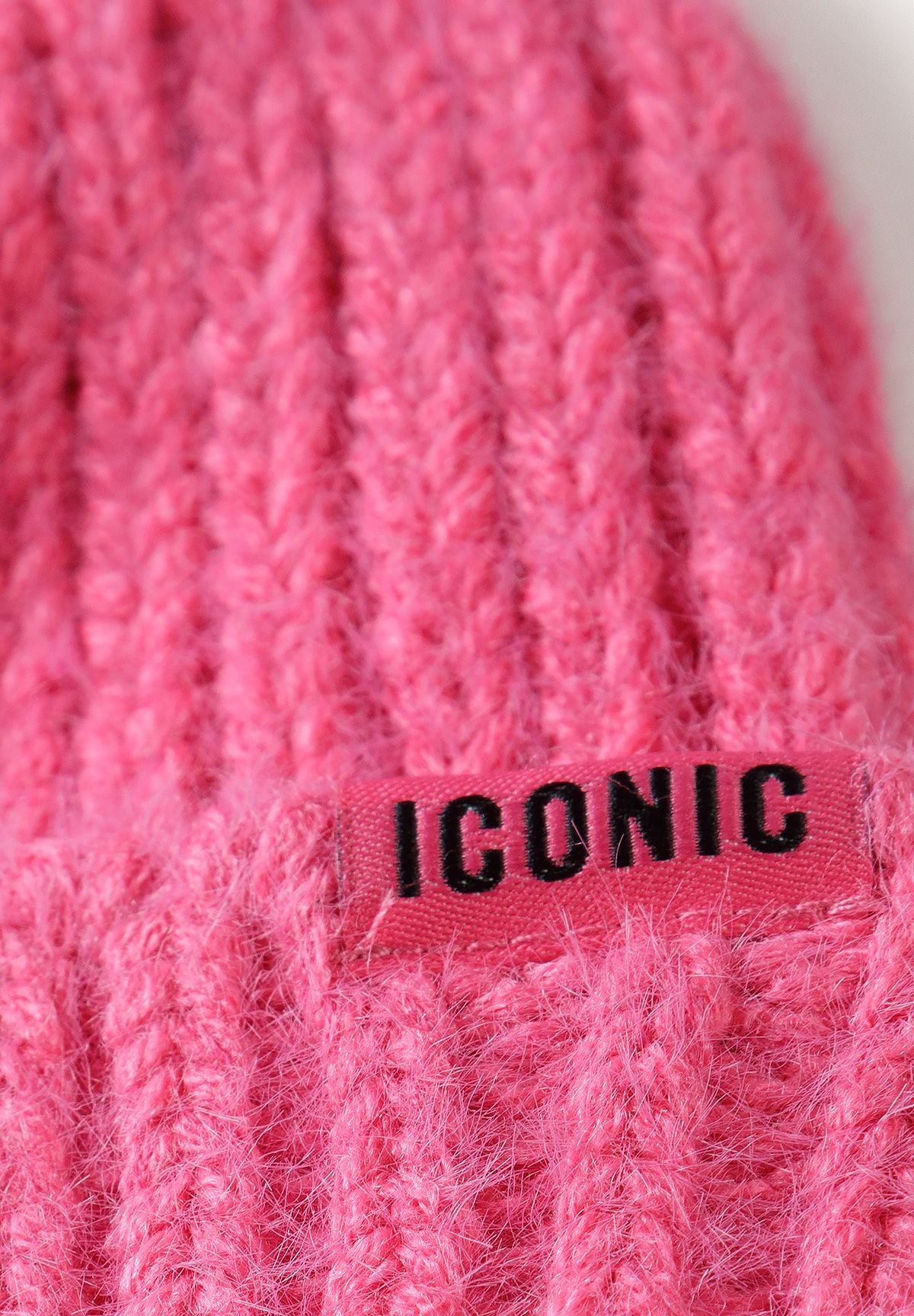 Bonnets côtelés roses et noirs pour filles avec un écusson Iconic (lot de 2), gros plan sur l'écusson Iconic du bonnet rose.