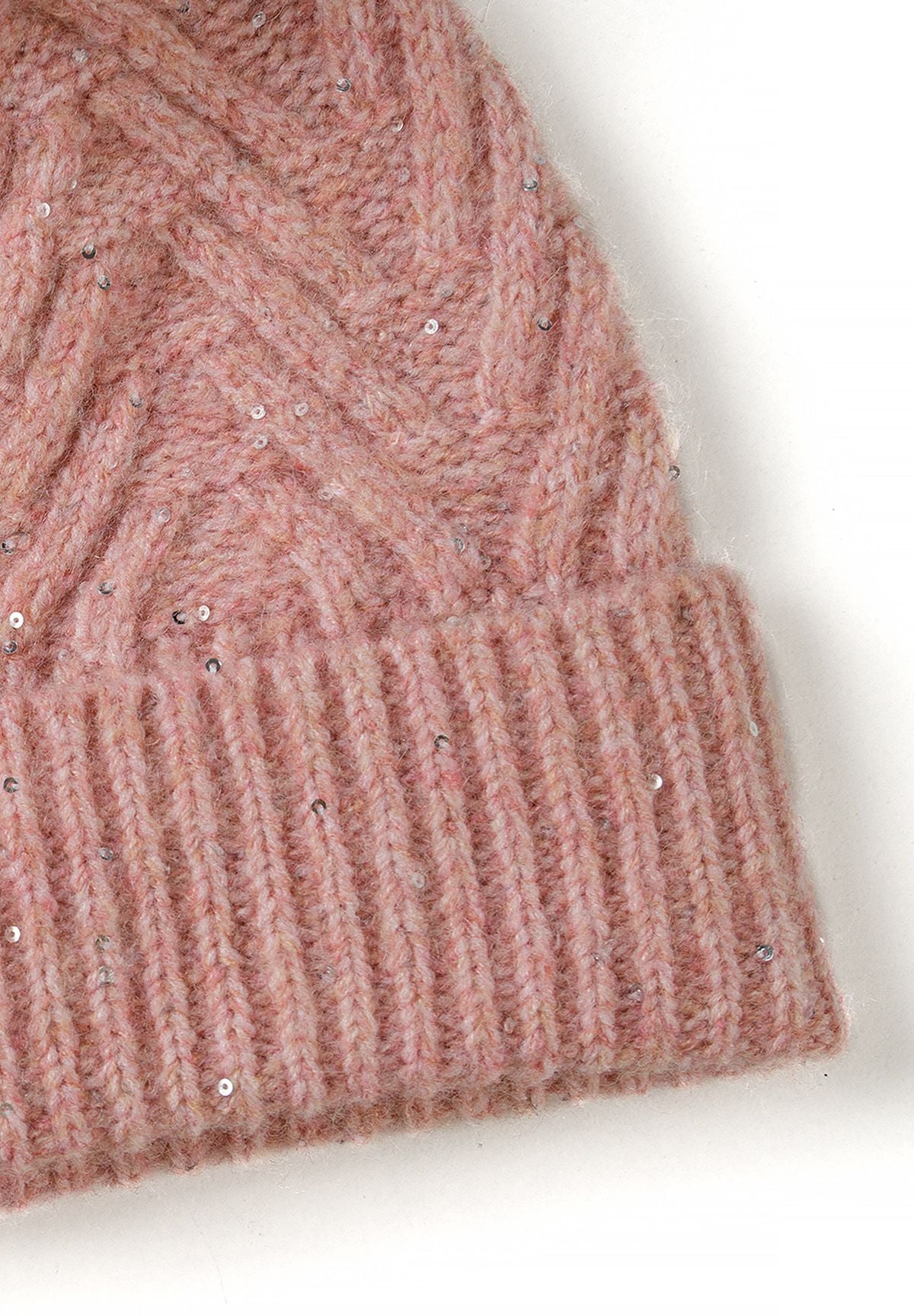 Close-up of dusty pink hat's raised chevron knit, scattered sequins and ribbed brim.