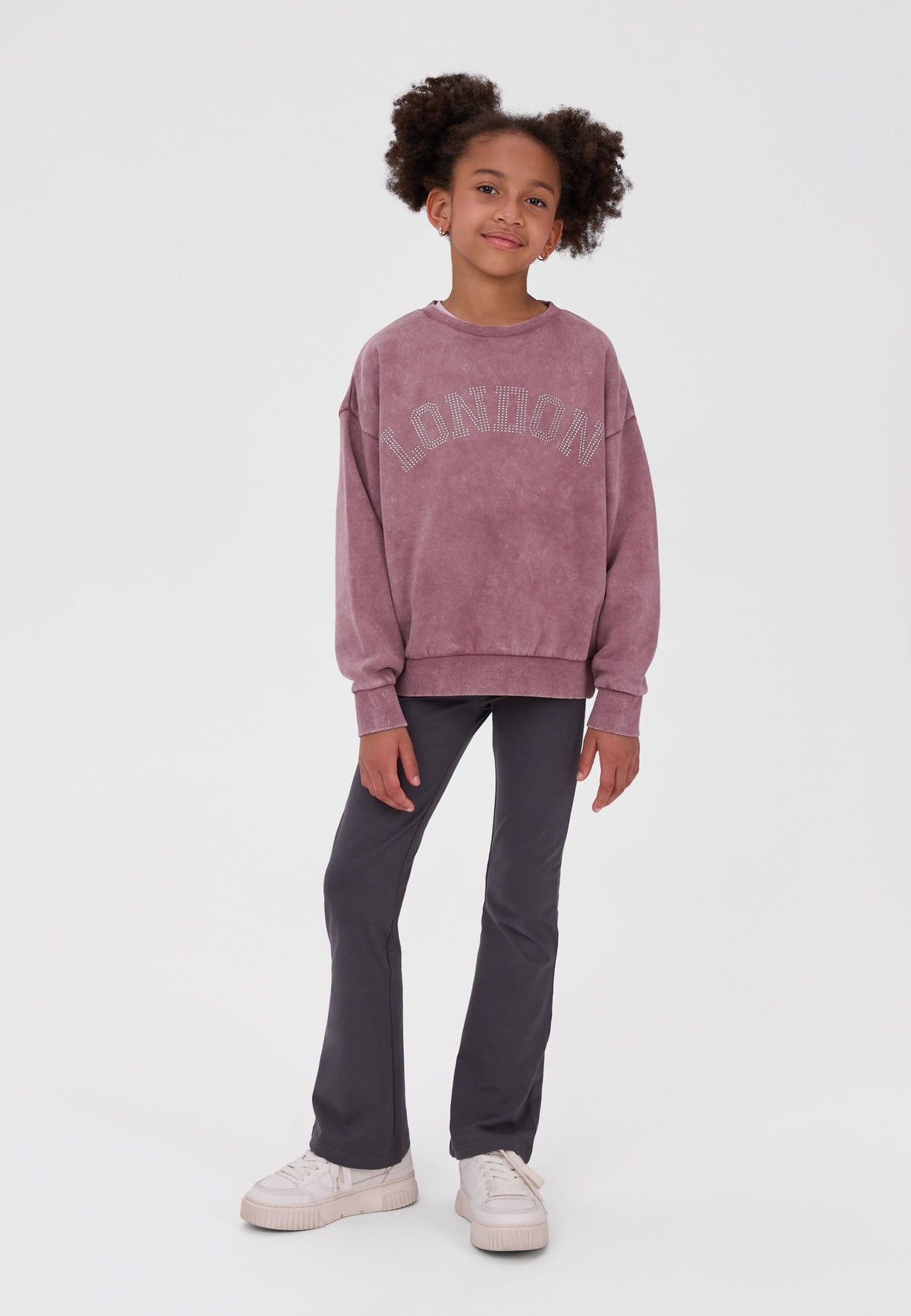 Girl wearing charcoal grey flared leggings with a plain elastic waist.