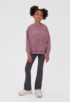 Girl wearing charcoal grey flared leggings with a plain elastic waist.