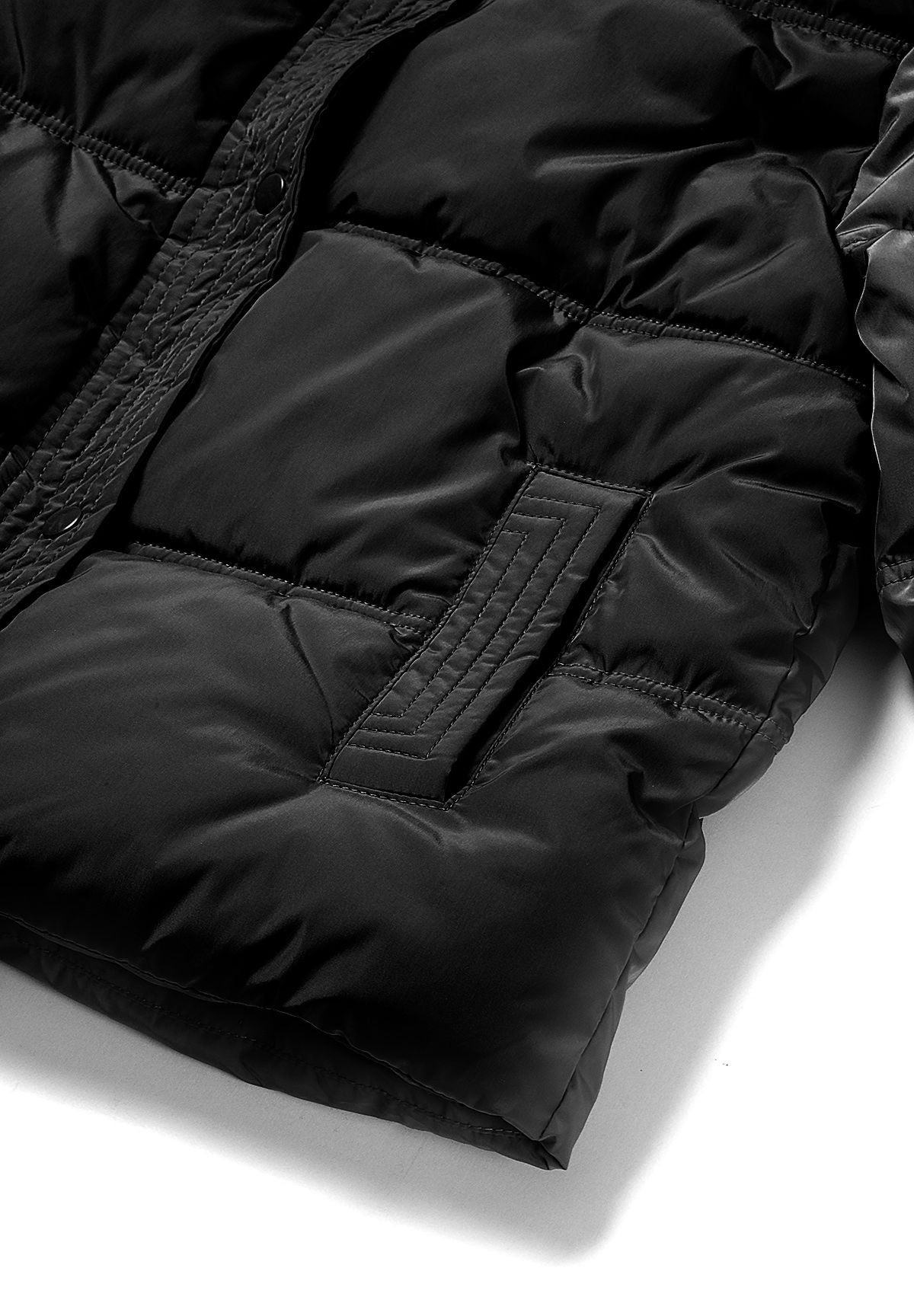 Close-up of a narrow black stitched welt pocket in the quilted puffer front.