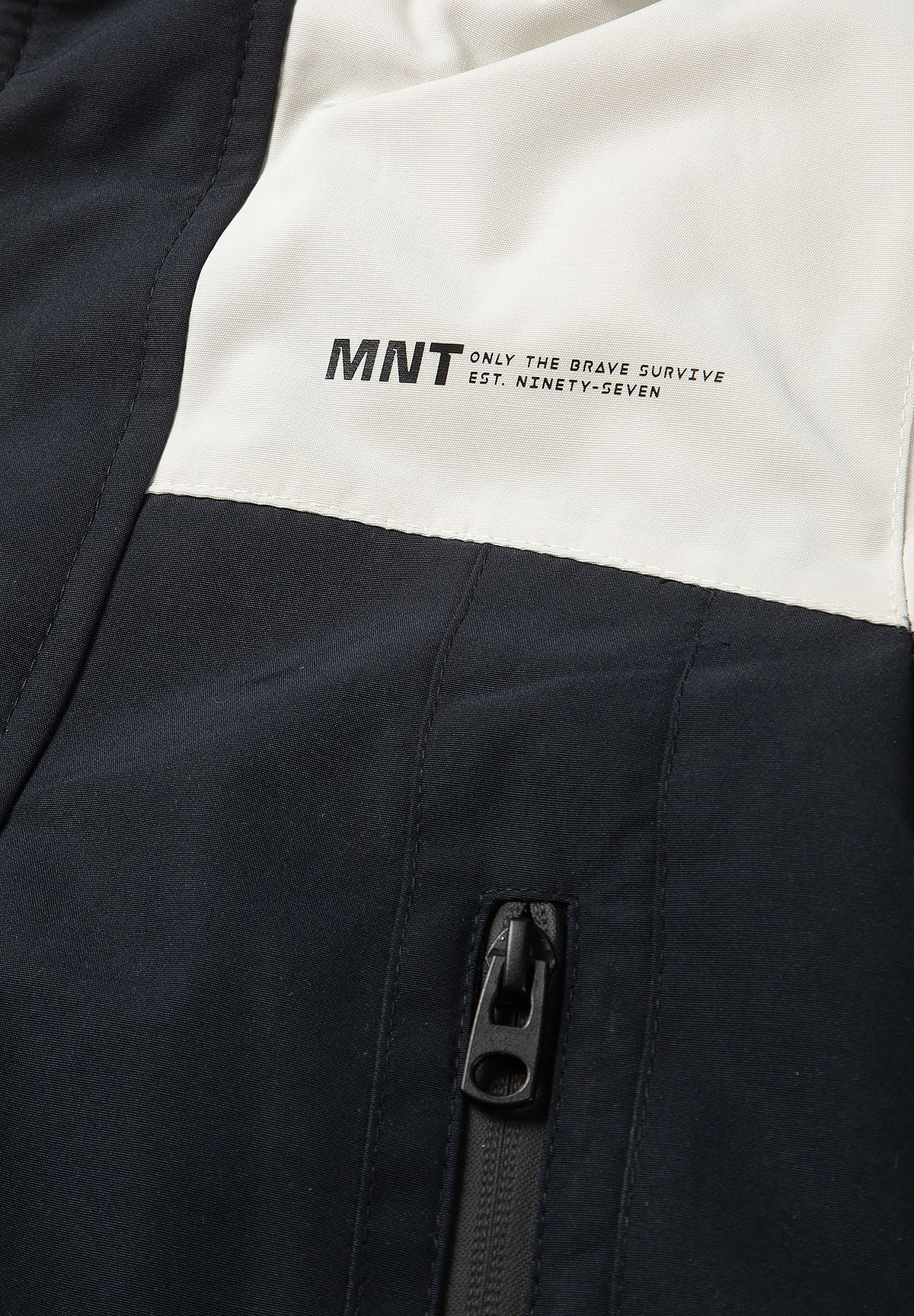 MNT chest print on the cream panel above the parka's black front and zipped pocket.