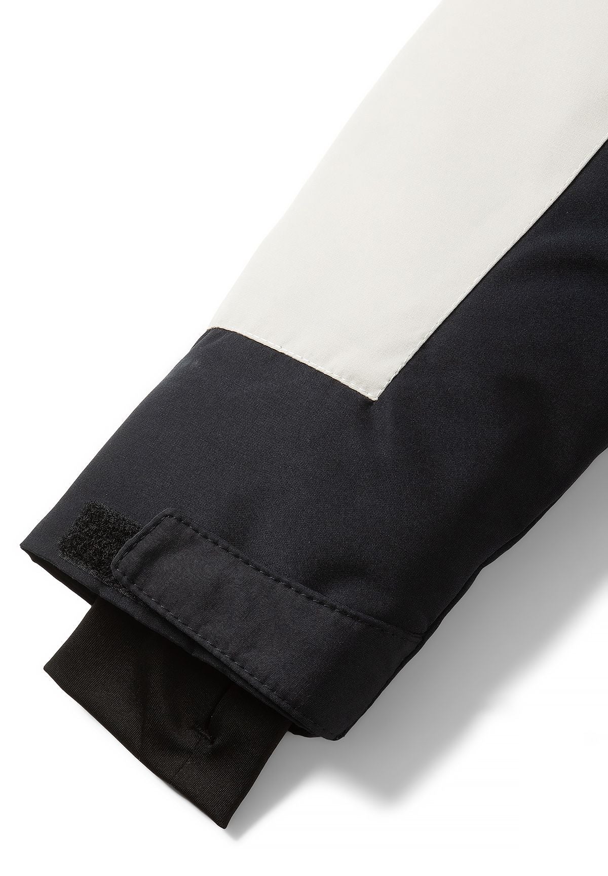 Cream and black parka sleeve with a hook-and-loop cuff tab and black ribbed inner cuff.
