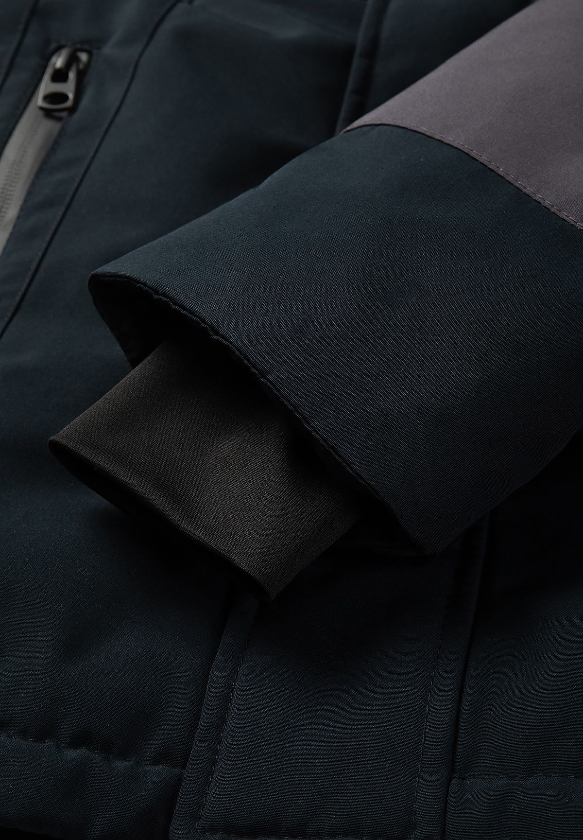 Close-up of the boys' parka sleeve showing a black ribbed inner cuff beneath the outer cuff.