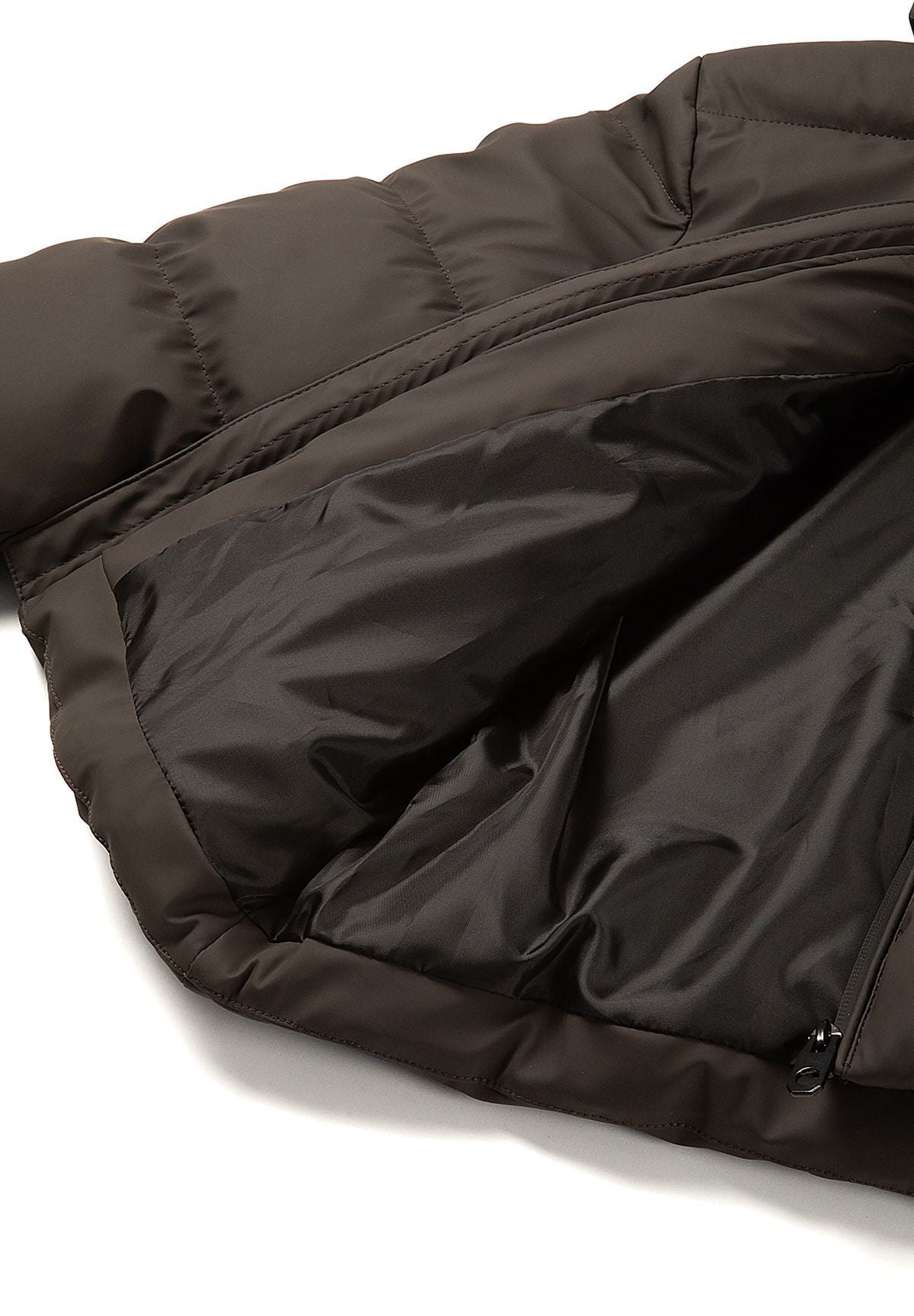 Inside of the dark brown puffer jacket showing smooth black lining beside padded outer shell.