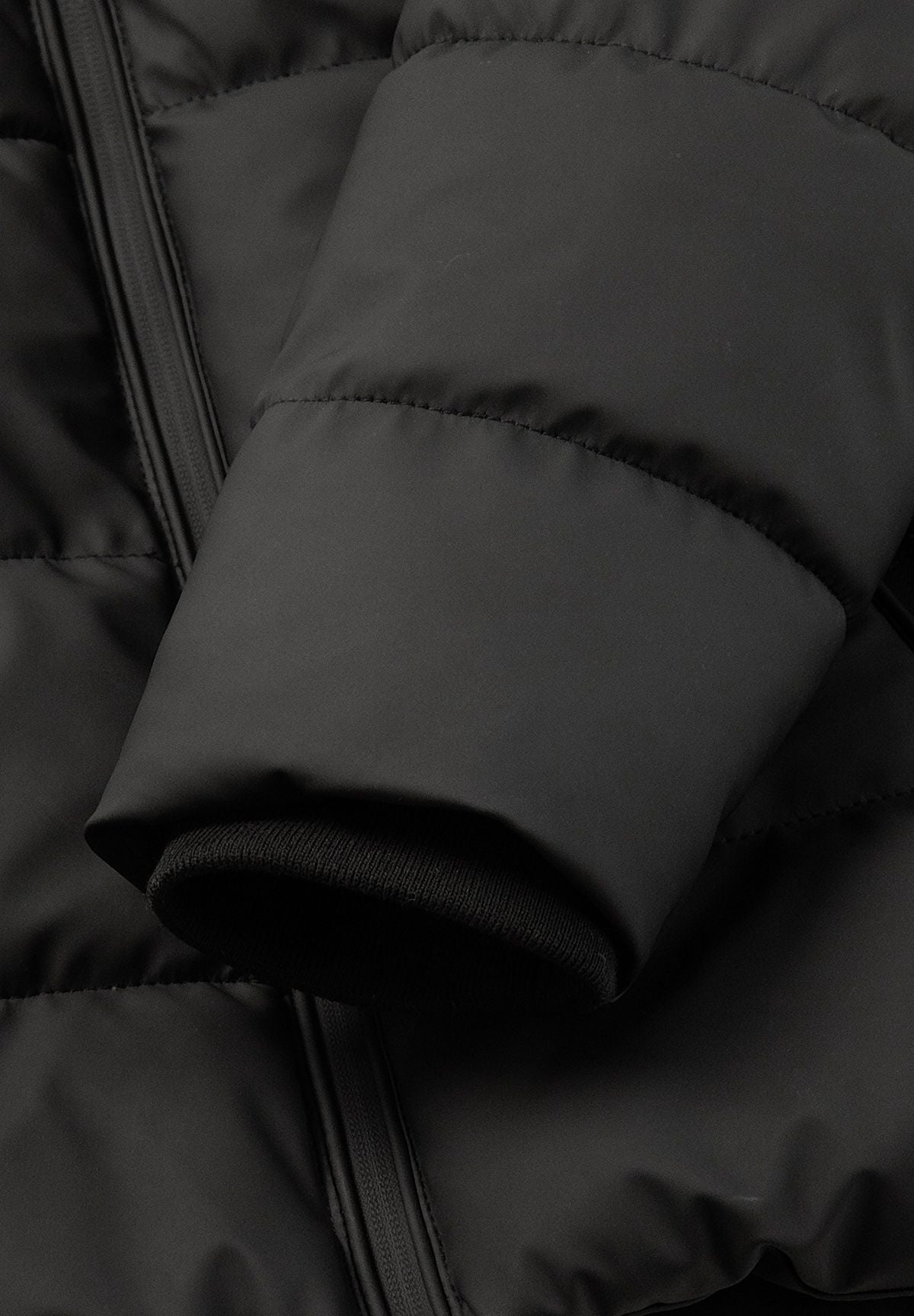 Close-up of a black padded sleeve with a ribbed inner cuff visible at the opening.
