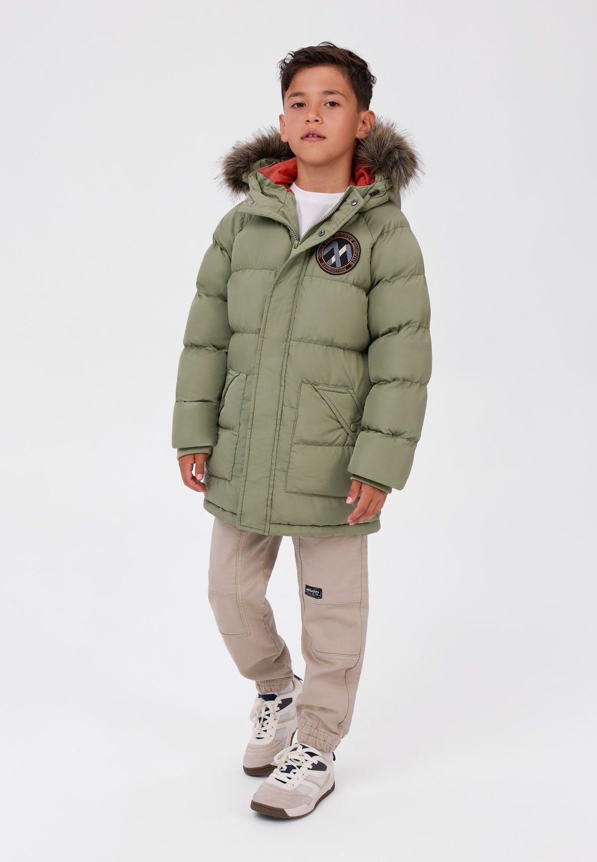 Parka acolchada de color oliva para niño con ribete de capucha desmontable, vista frontal del modelo.