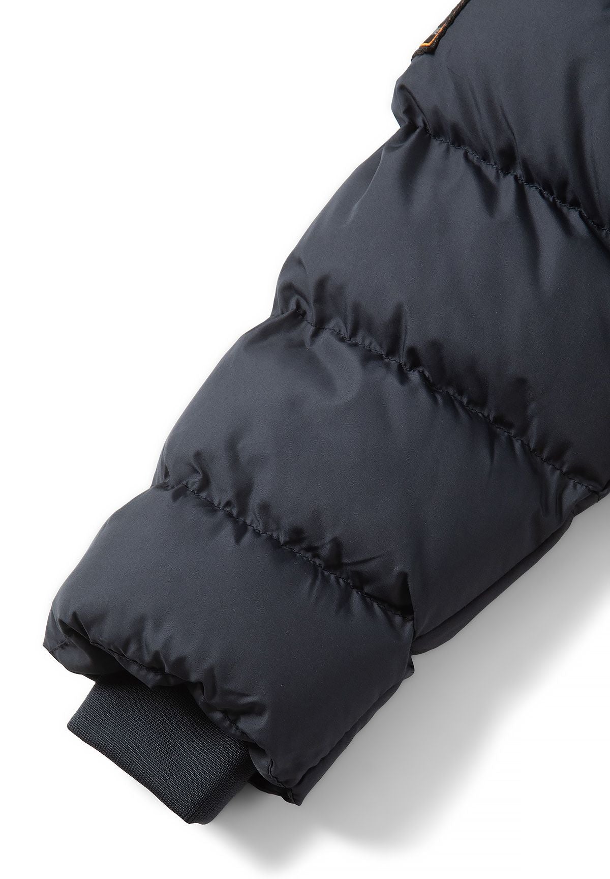 Donkerblauwe gewatteerde parka voor jongens met afneembare capuchonrand, detail van de manchet.