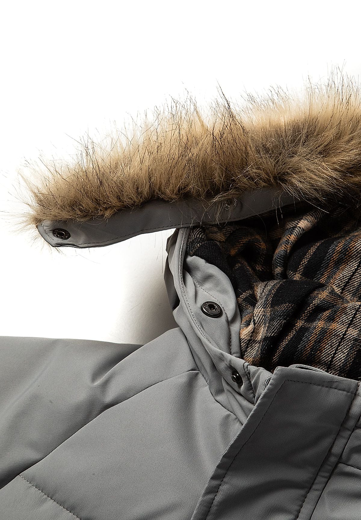 Grijze en rode gewatteerde parka met kleurblokken voor jongens, detail van de rand van de capuchon en de voering met ruitjespatroon.