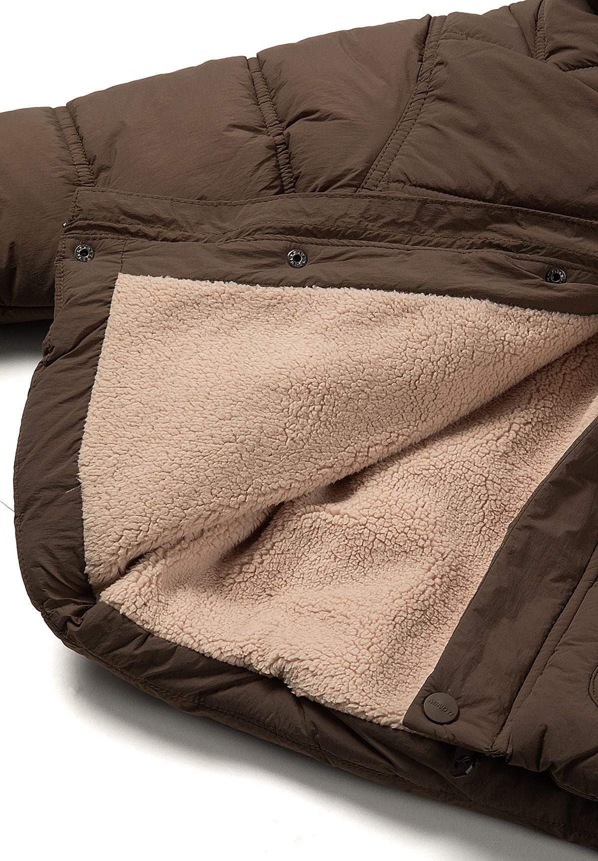 Inside view of thick beige teddy lining within the brown padded jacket.