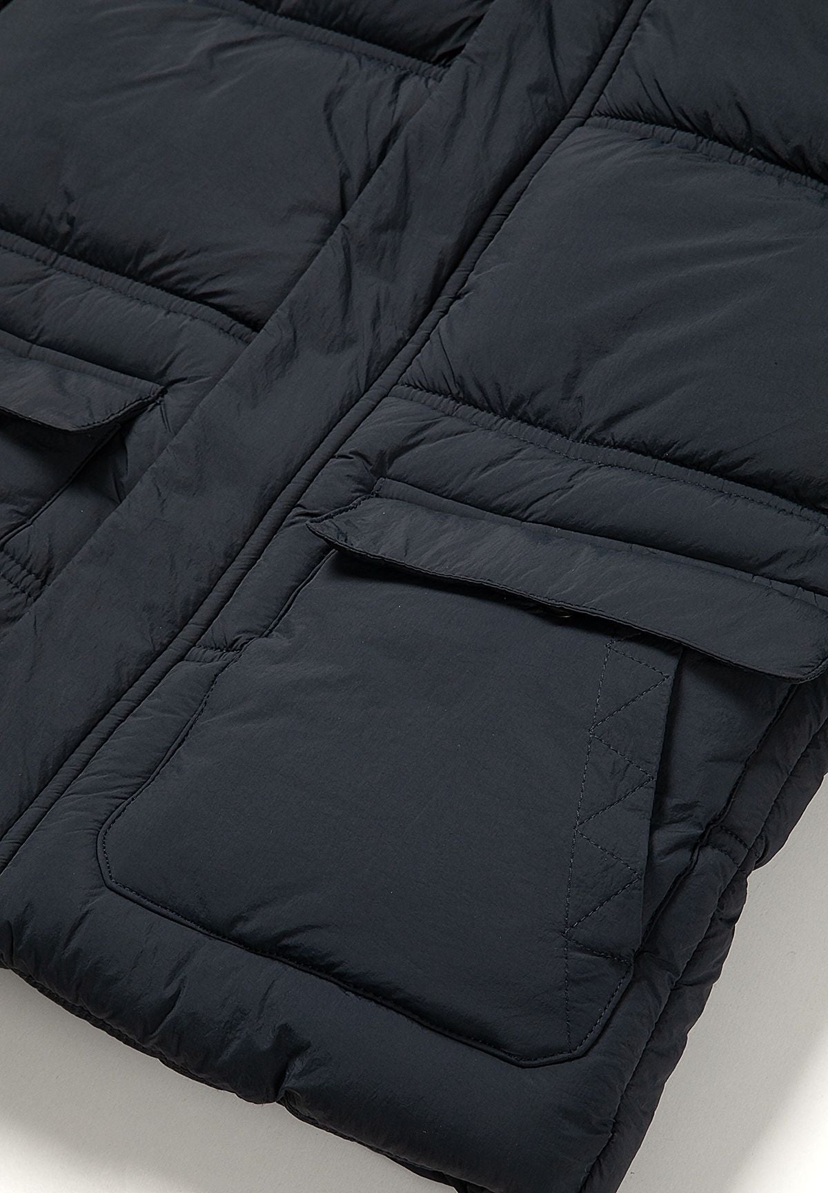 Piumino da ragazzo blu navy con cappuccio, primo piano della tasca con patta.