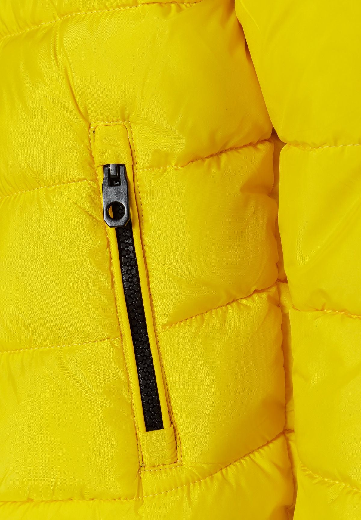 Close-up of a black vertical side-pocket zip set into bright yellow quilted jacket fabric.