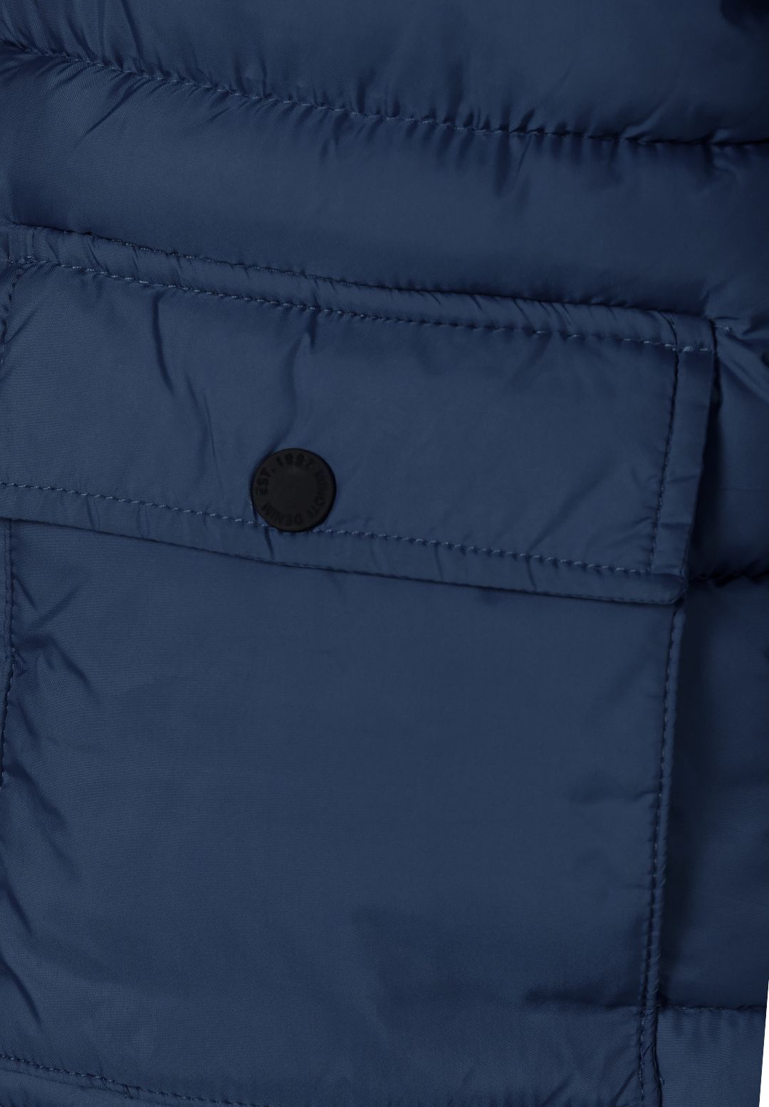 Close-up of a navy parka patch pocket with a straight flap and single black snap.