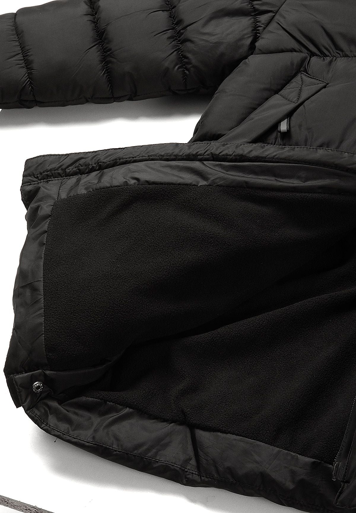 Inside view of the black padded coat with dark fleece-looking body lining and side hem popper.