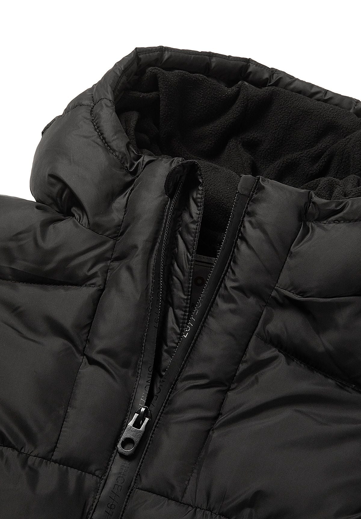 Close-up of the black coat's central zip and dark fleece-lined hood opening.