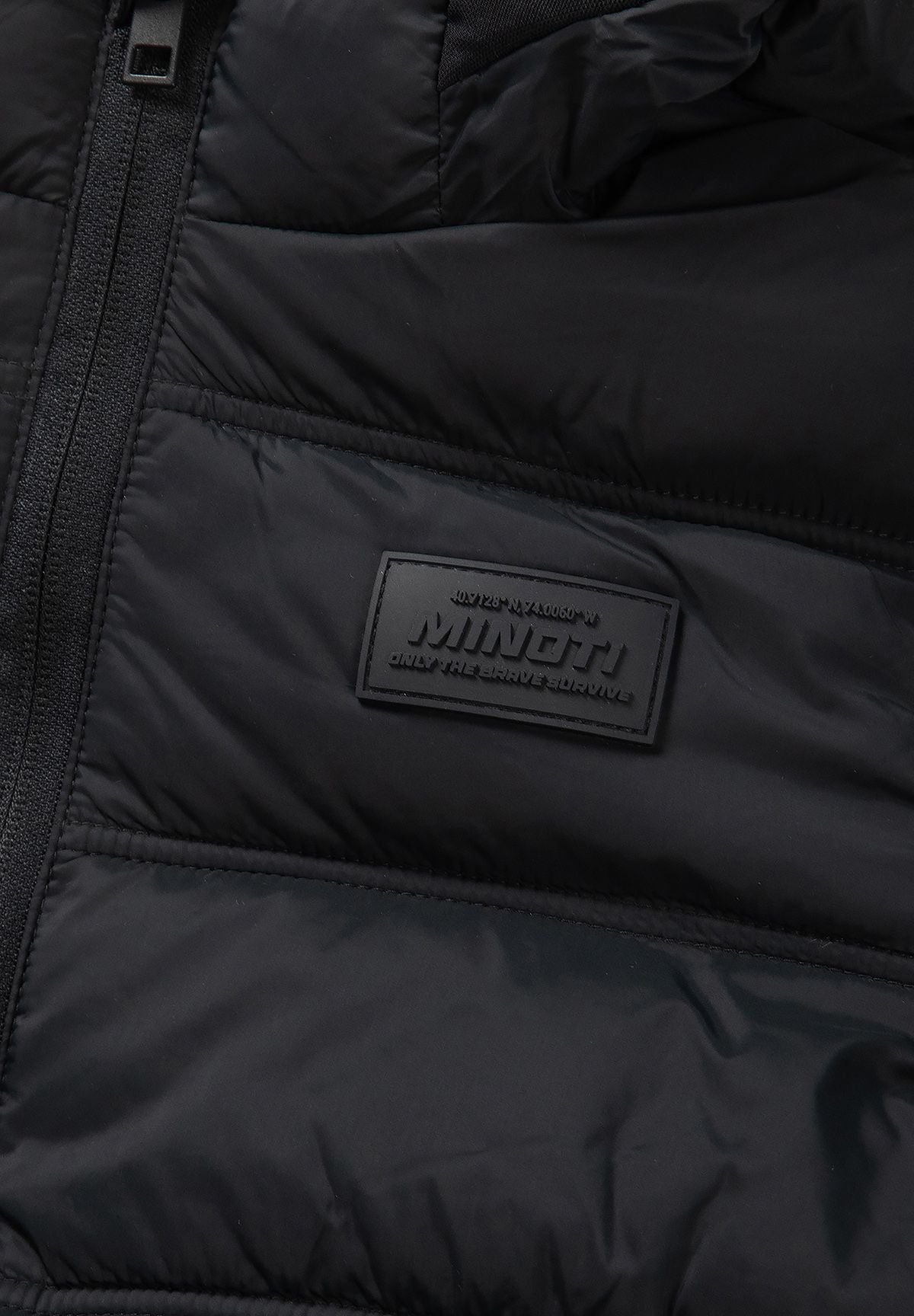 Tonal MINOTI chest patch above the black puffer jacket's broad quilt stitching.