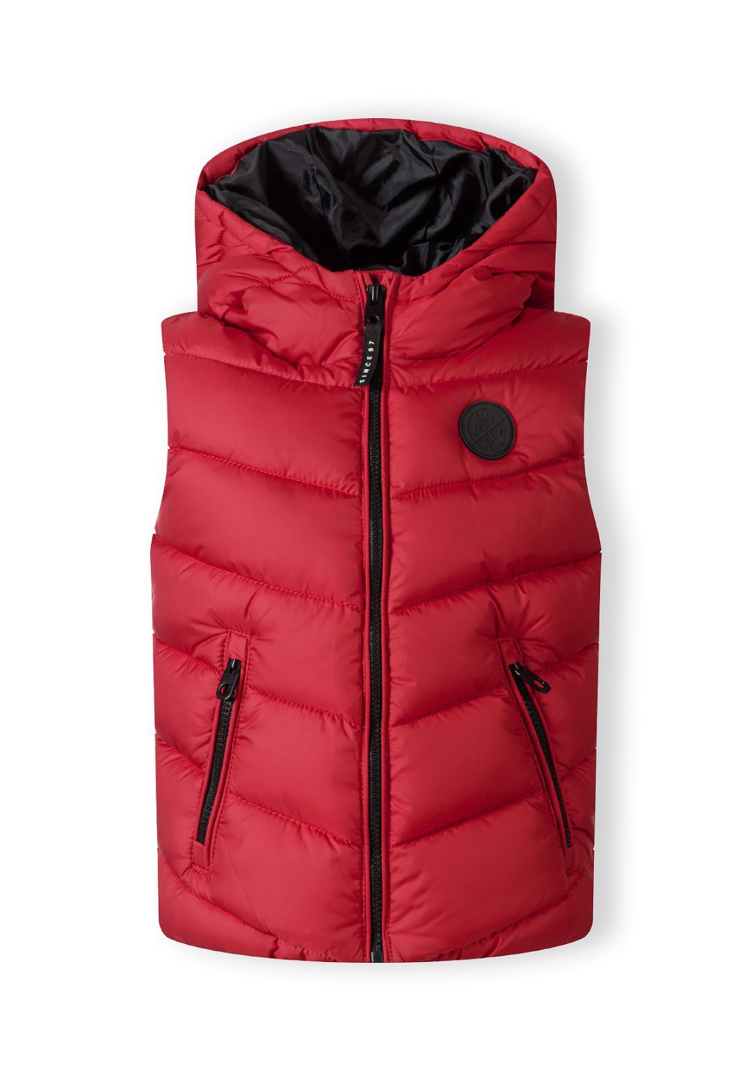 Front of red quilted hooded gilet with black central zip, zipped side pockets and round chest badge.