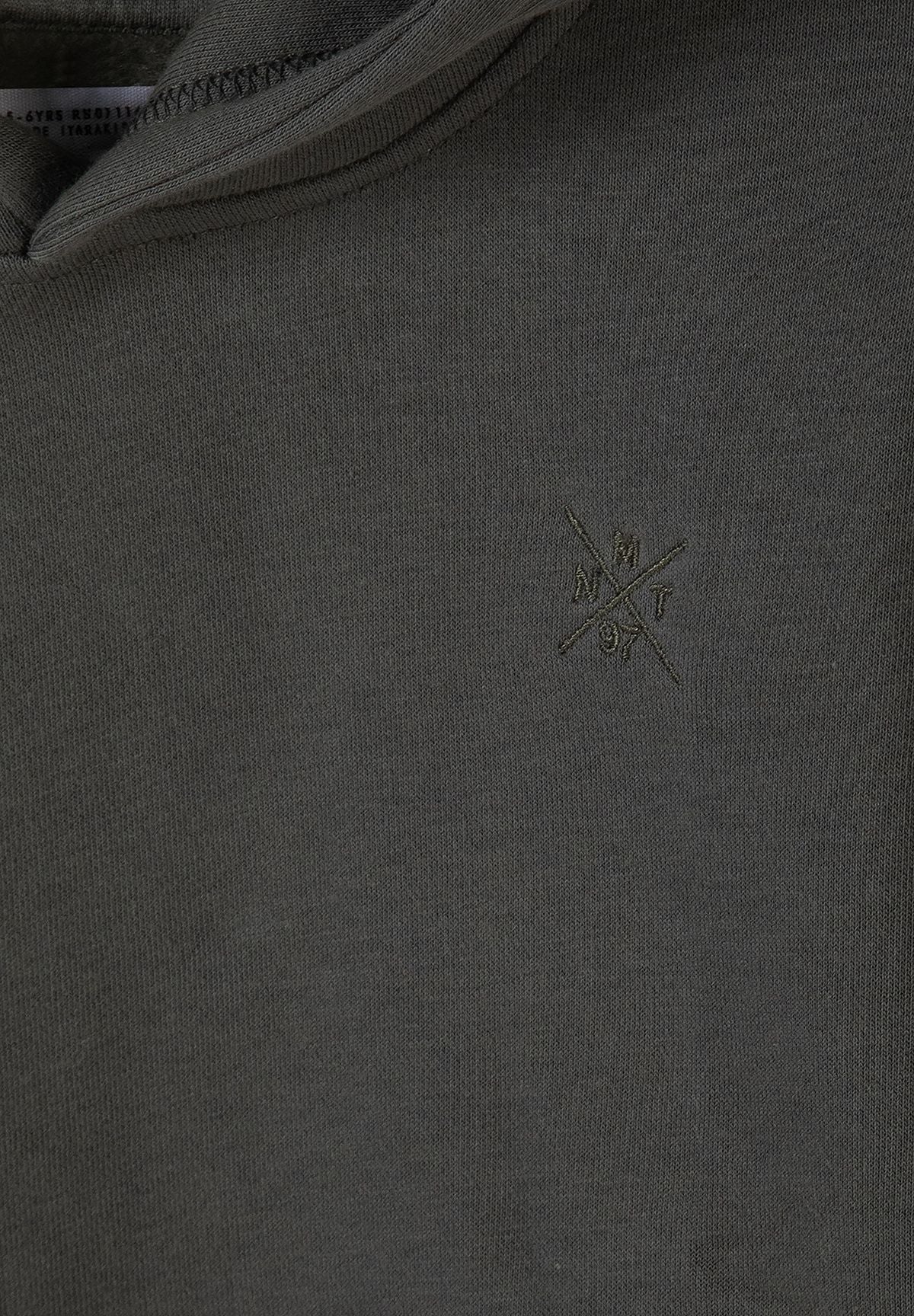 Close-up of grey-olive hoodie fabric and small tonal crossed chest embroidery.