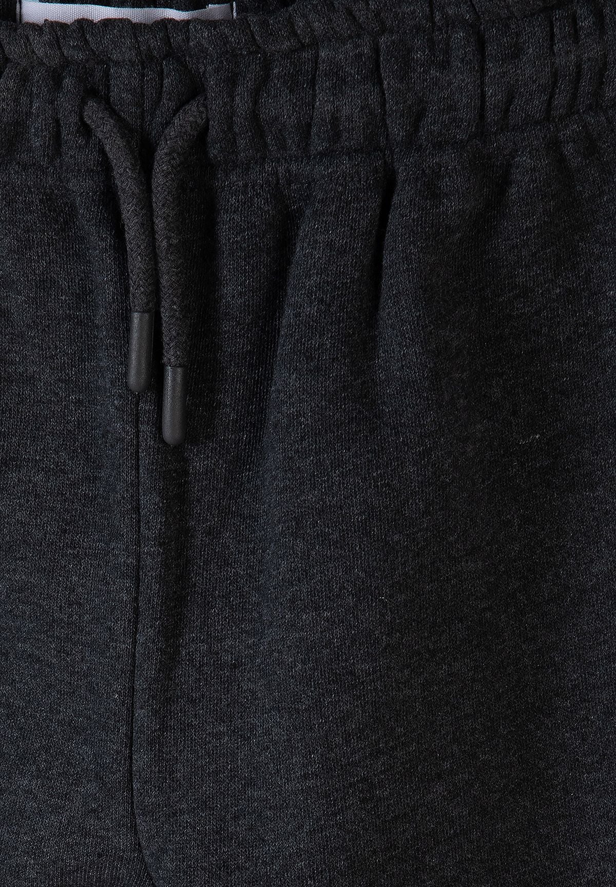 Antracietgrijze trainingsset voor jongens met een hoodie met rits en een joggingbroek, detail van de tailleband met trekkoord.
