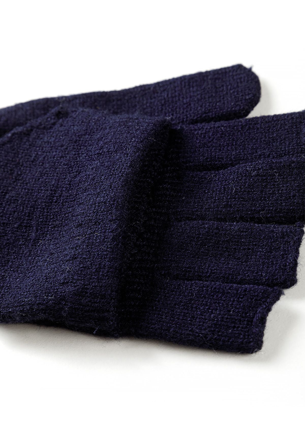 Ensemble composé d'un bonnet bleu marine et de gants convertibles pour garçon, gros plan sur le tricot des gants.