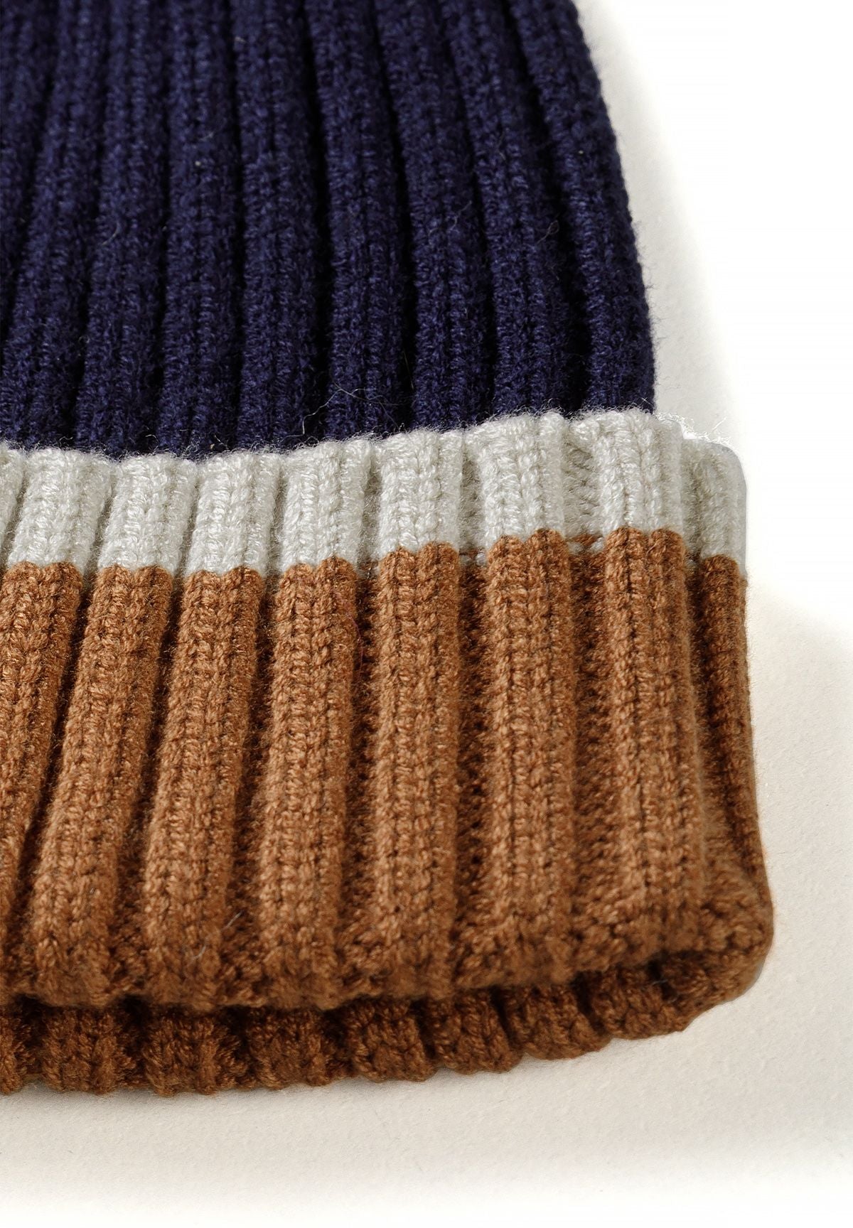 Ensemble composé d'un bonnet bleu marine et de gants convertibles pour garçon, gros plan sur le revers rayé.